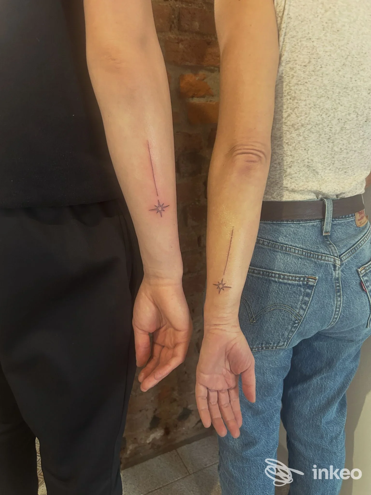 Due avambracci con tatuaggi lineari e piccole stelle alle estremità, esposti sulla pelle chiara, senza testi o elementi promozionali.