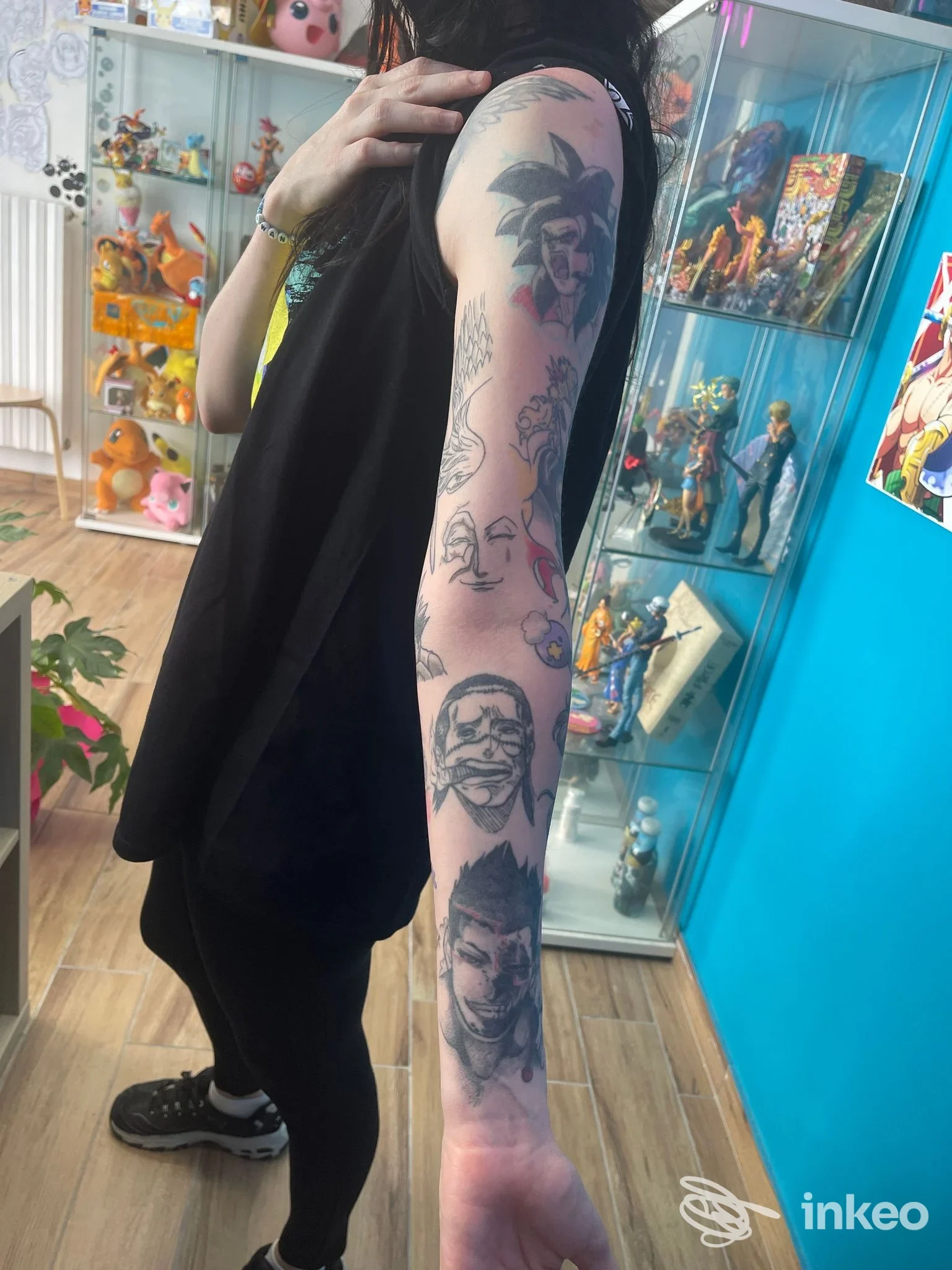 Tattoo sull'avambraccio di una persona all'interno di uno studio, disegni a inchiostro lungo la pelle, senza visione del volto.