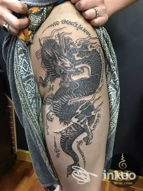 Grande tatuaggio nero di un drago sul fianco e coscia, opera di Studio Test INKEO 2, foto in interno.