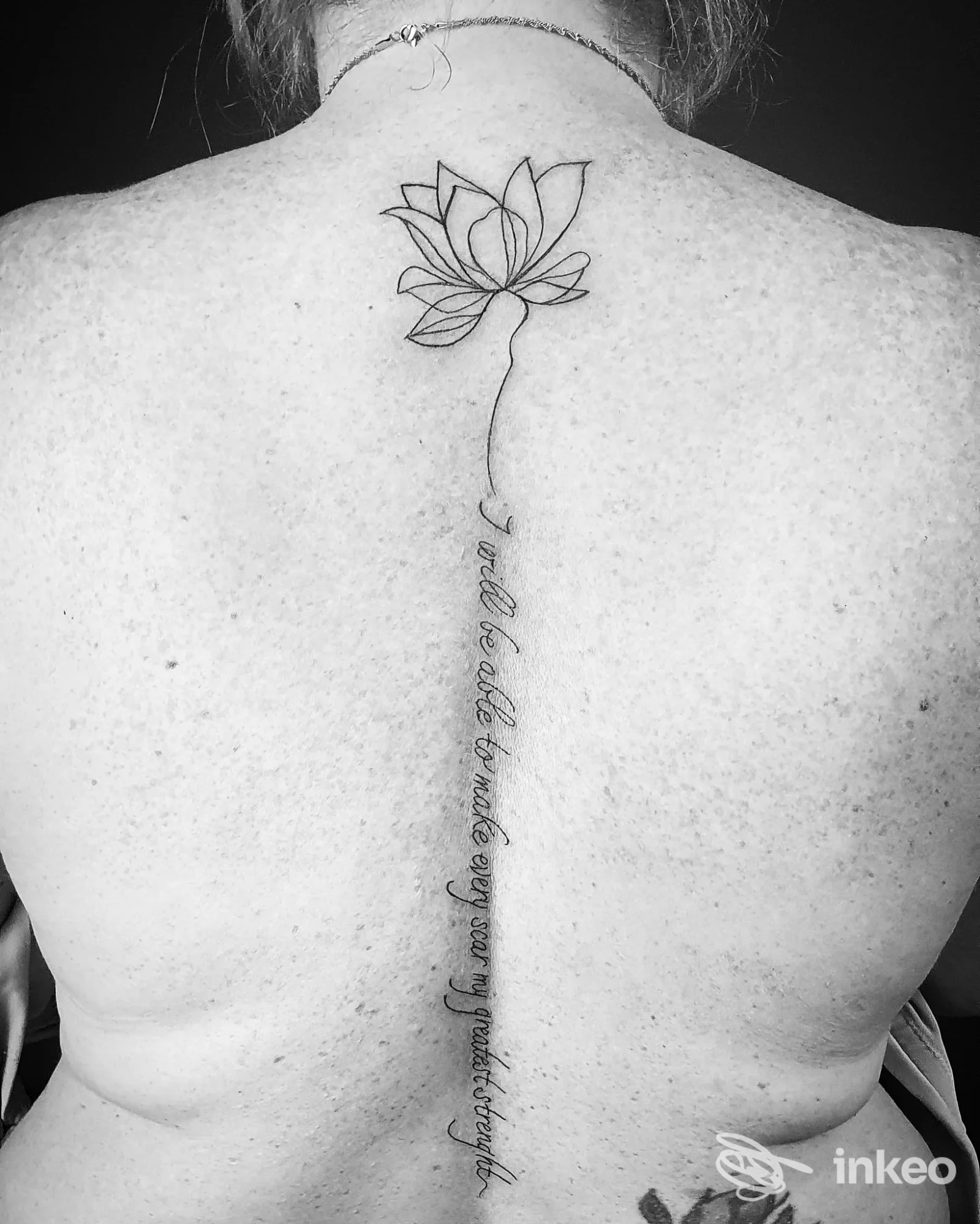 Tattoo lotus sul dorso con linea verticale lungo la colonna vertebrale, realizzato sulla pelle della schiena, studio Gold Hand Studio, Vasto.