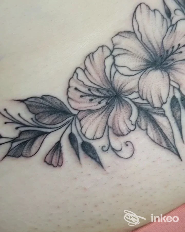 Tatuaggio floreale in bianco e nero con sfumature rosa su pelle, realizzato dallo studio Black Lily a Bussi sul Tirino.