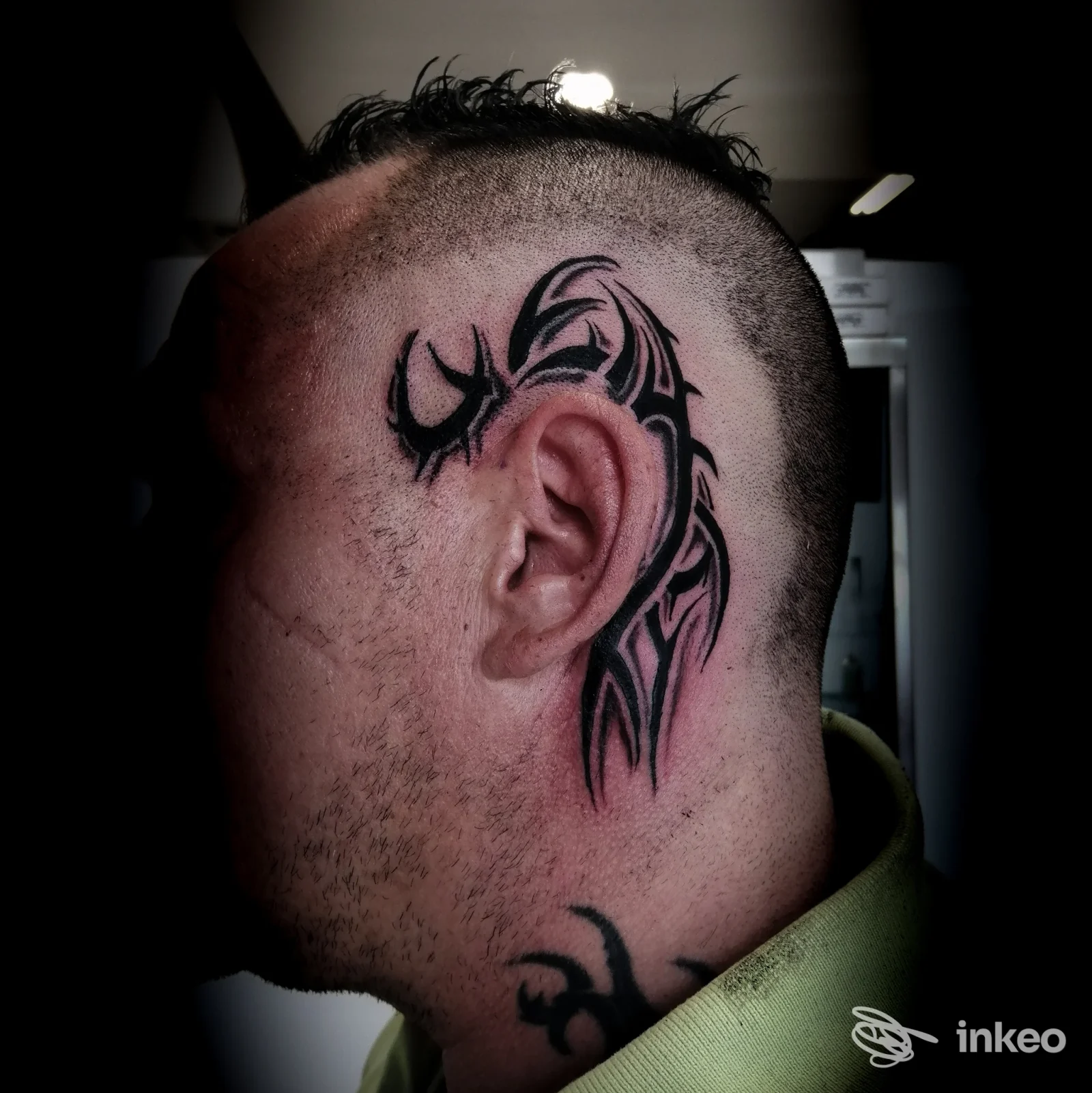Veduta laterale della testa con tatuaggio tribale nero realizzato sulla pelle vicino all'orecchio, visibile su una persona nello studio Kali’s Kiss a Pescara.