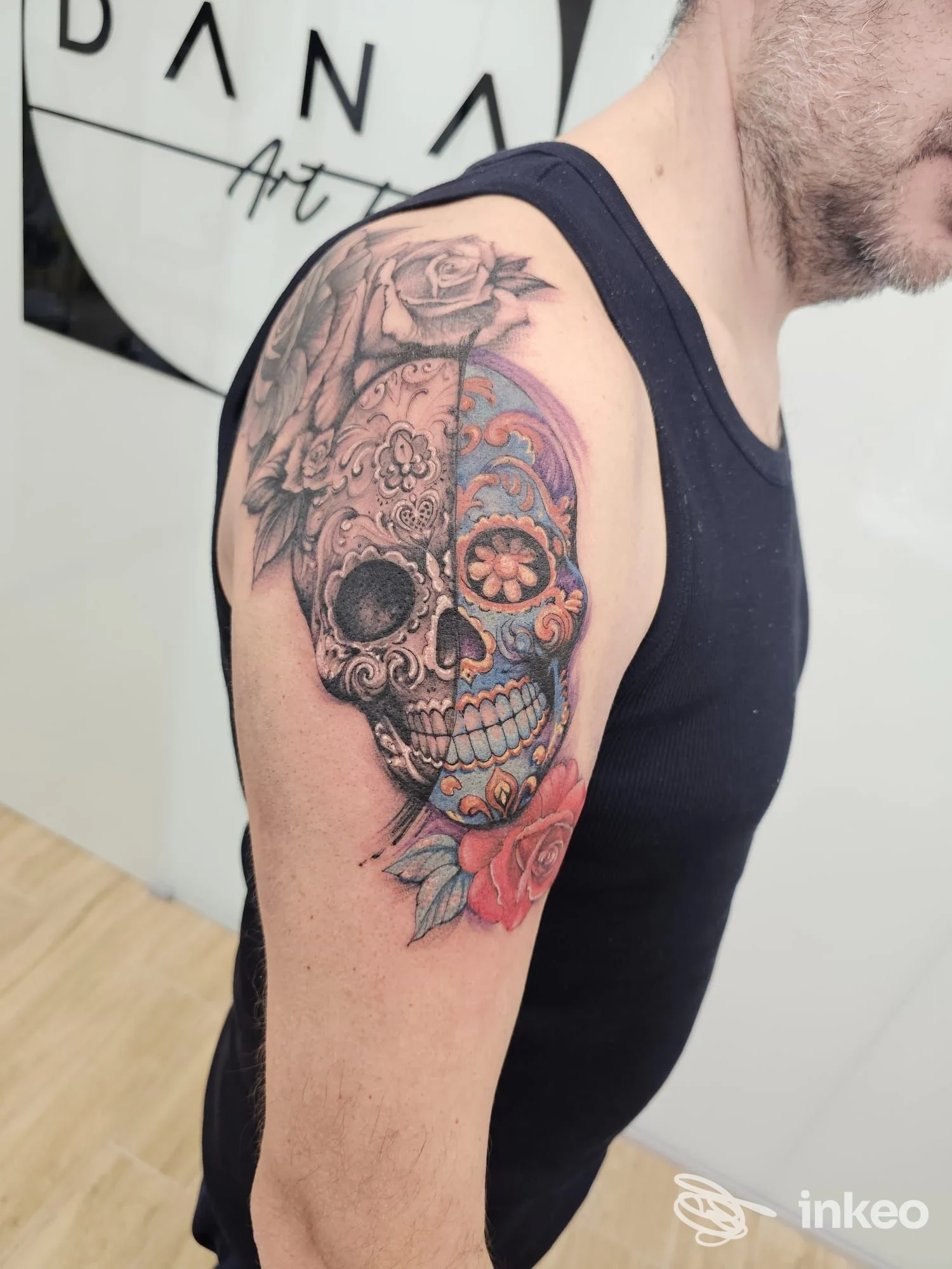 Tattoo a tema sugar skull con fiori colorati sul braccio di un uomo, realizzato nello studio Dana Art Tattoo a Pescara.