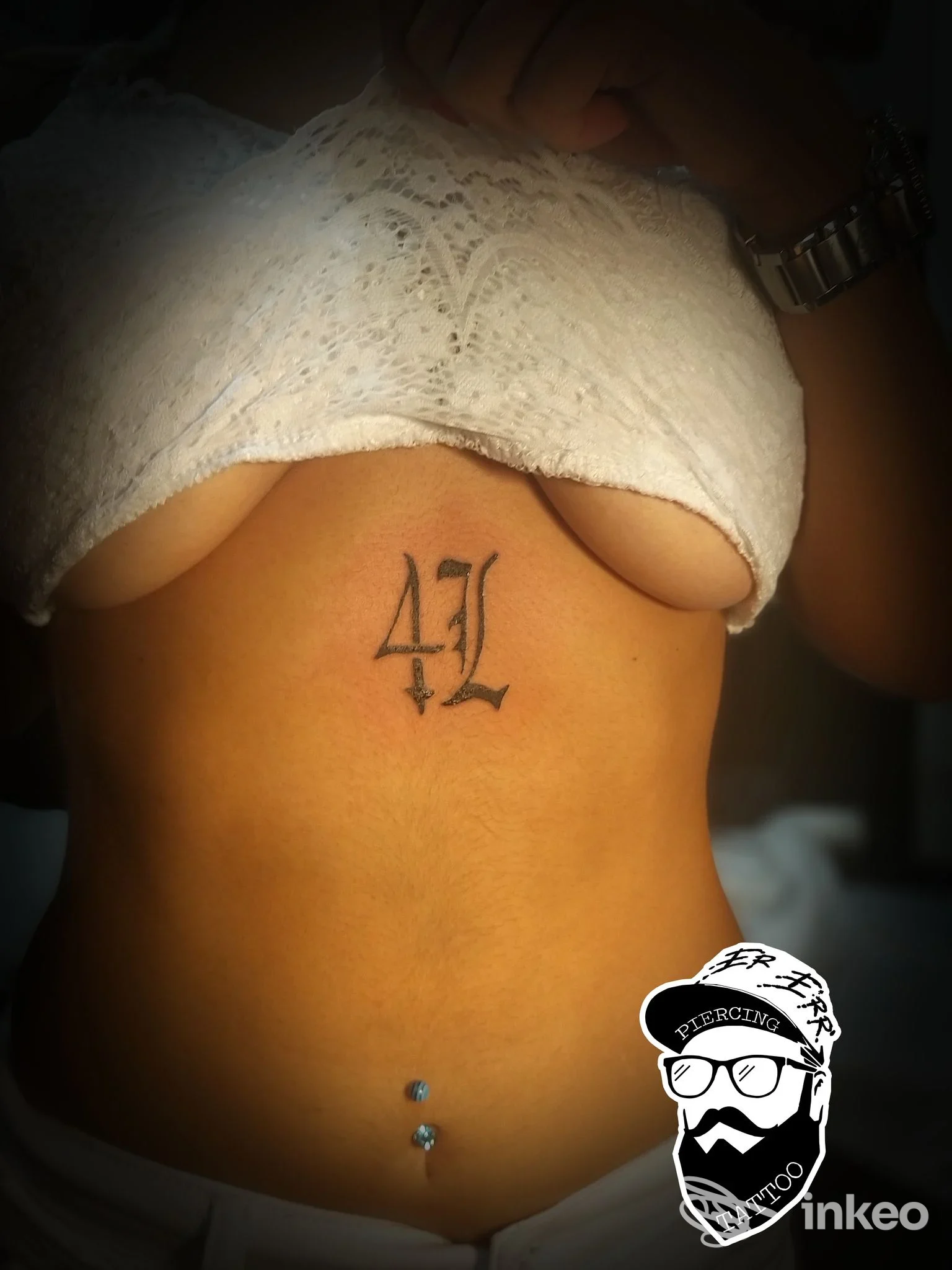 Addome di persona con tatuaggio stilizzato '41' visibile mentre la maglietta è sollevata, scatto dall'addome superiore; proveniente dallo studio Crazy Ink 667 a Marina di Vasto.