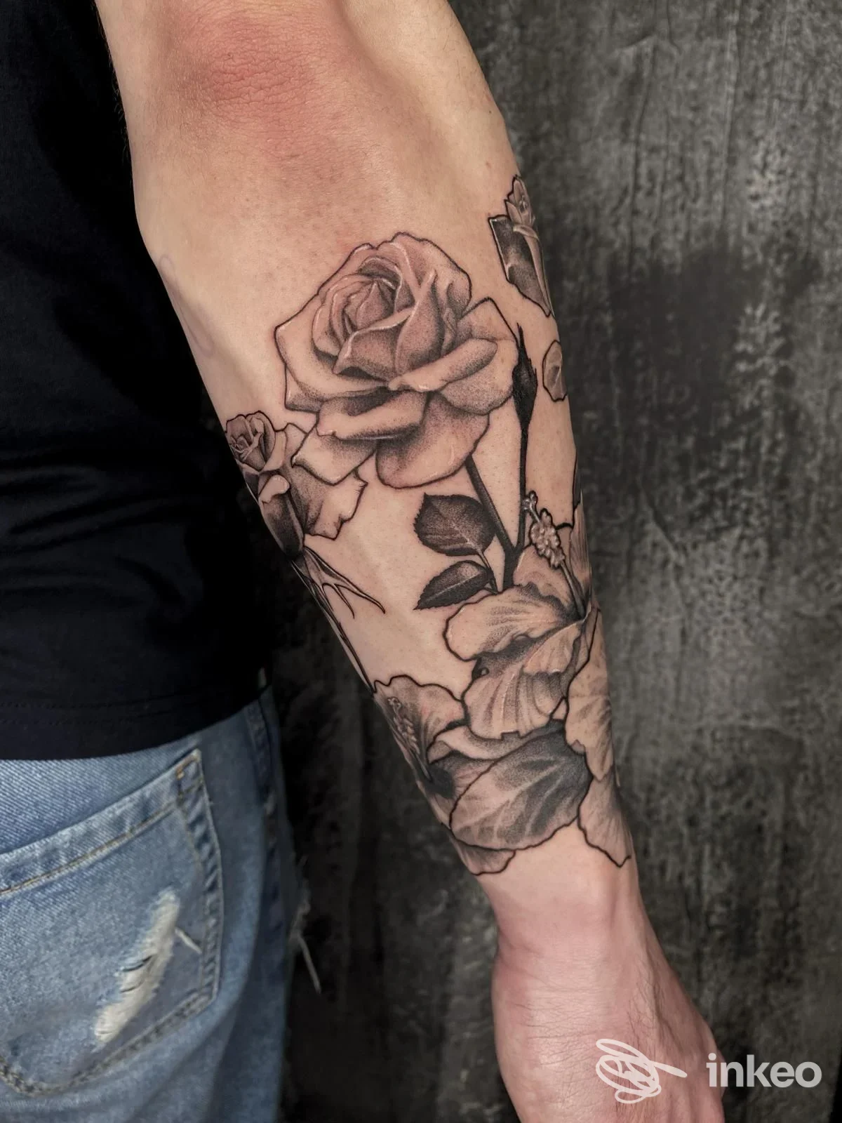Tattoo realistico di rose su avambraccio visibile, eseguito su pelle reale presso Inusuali Ink Tattoo Studio, Torre de' Passeri.