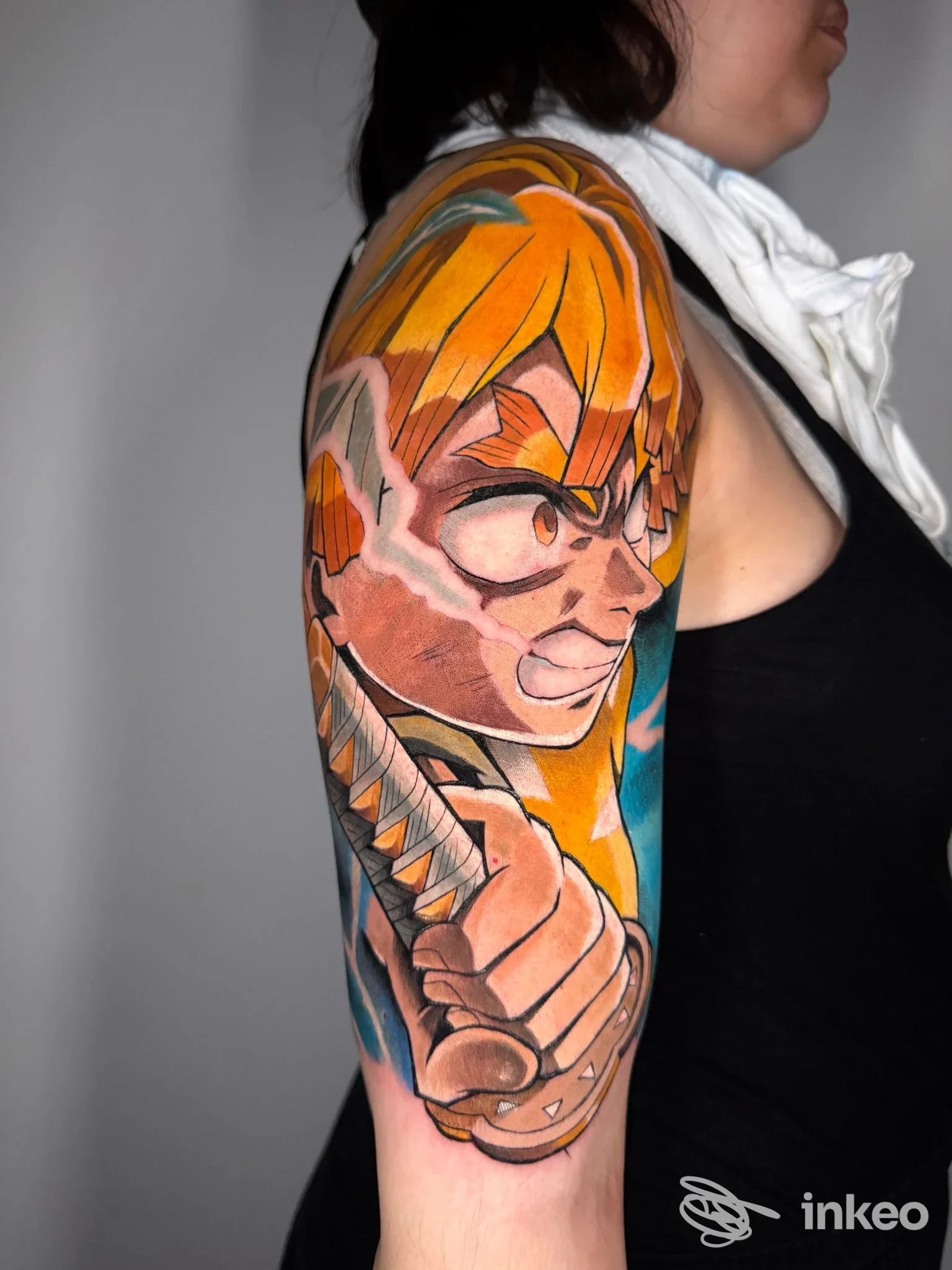 Tattoo a colori sul braccio di una persona, raffigurante un personaggio anime con spada, visibile in stile ritratto laterale; studio Hagakure Tattoo Studio a Chieti.