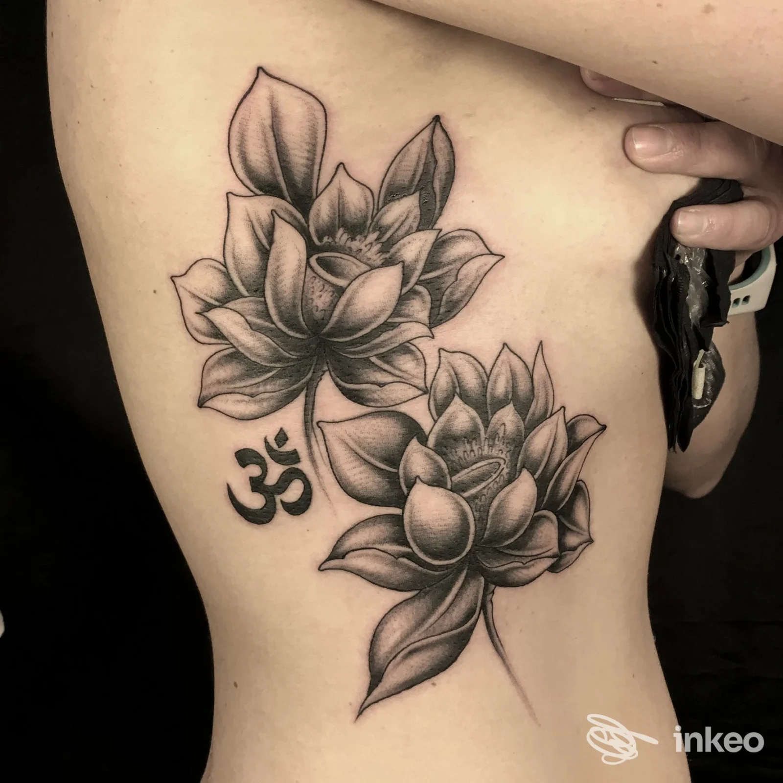 Tatuaggio realistico su pelle, raffigurante due succulente sul fianco sinistro; simbolo Ohm posto vicino al disegno. realizzato dallo studio Rumble Tumble Tattoo, L'Aquila.