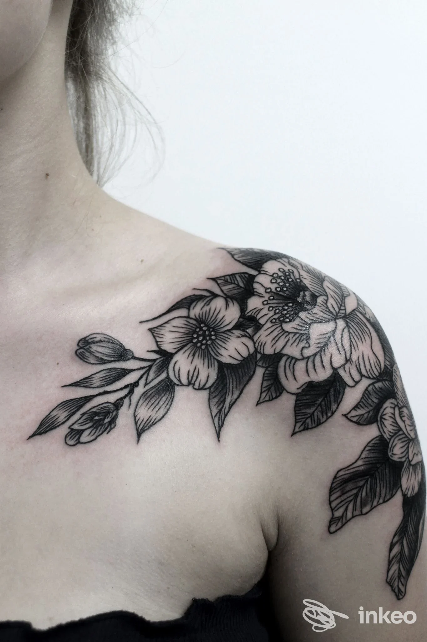 Tattoo floreale nero sulla spalla sinistra, realizzato sulla pelle di una modella, stile botanico; Vik Tattoo Studio, Pescara.