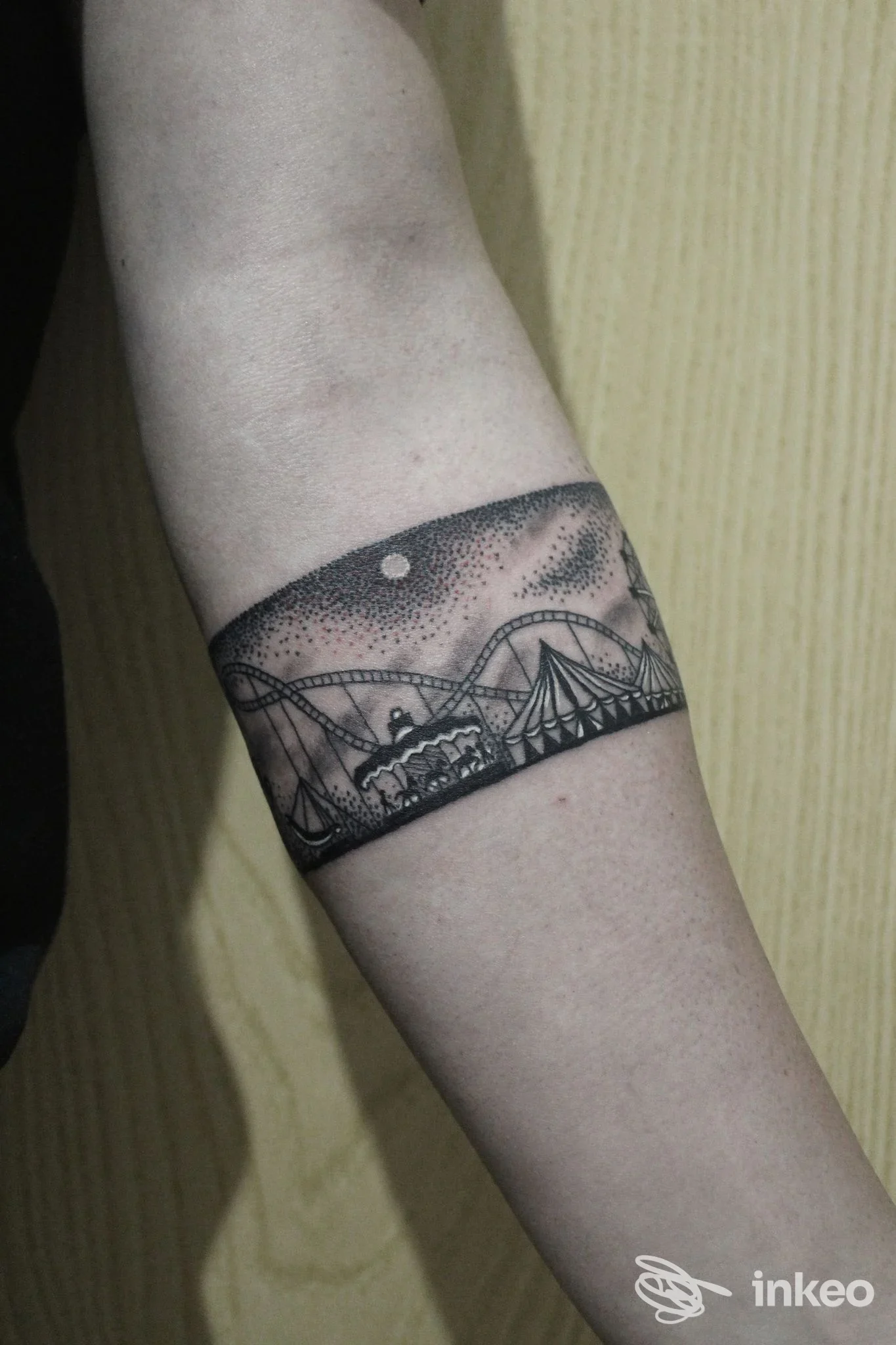Tattoo artistico su braccio, fascia orizzontale con paesaggio urbano e cielo stellato, realizzato presso Vik Tattoo Studio a Pescara.