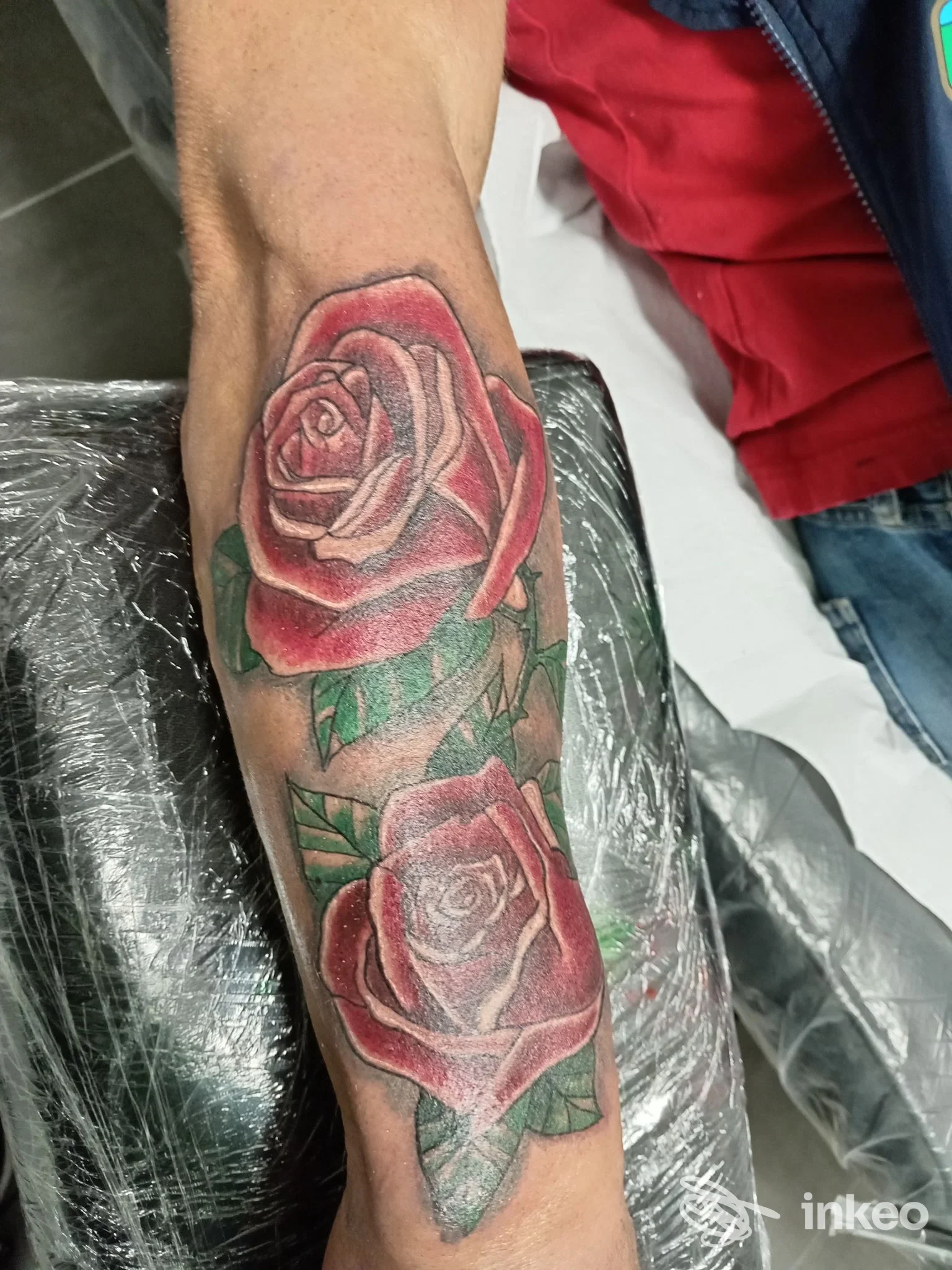 Tattoo realistico di rose rosse sull'avambraccio, colori vividi e sfumature, realizzato su pelle, visibile in studio Nina Tattoo Studio a Francavilla al Mare.