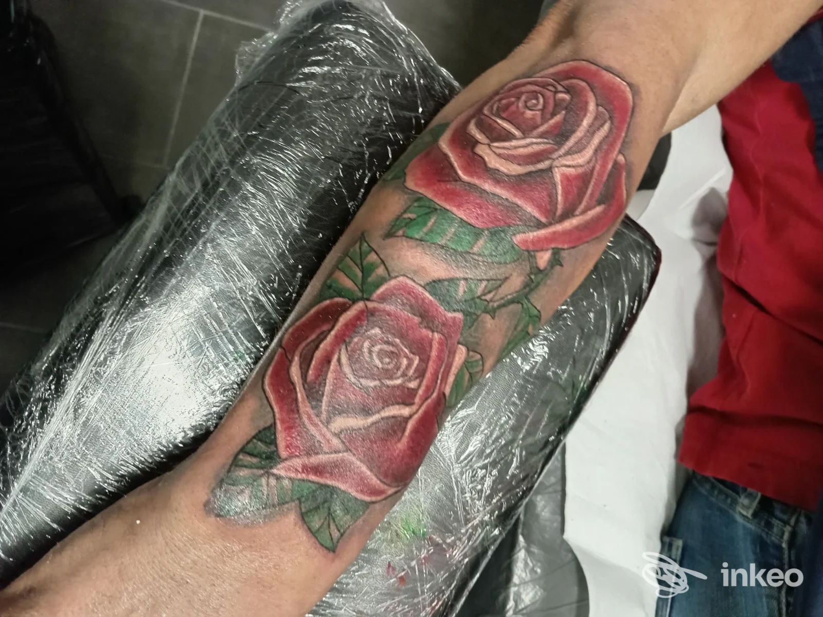 Brazo con due rose tatuate su pelle, senza volto visibile, foto chiara e nitida della parte tatuata.
