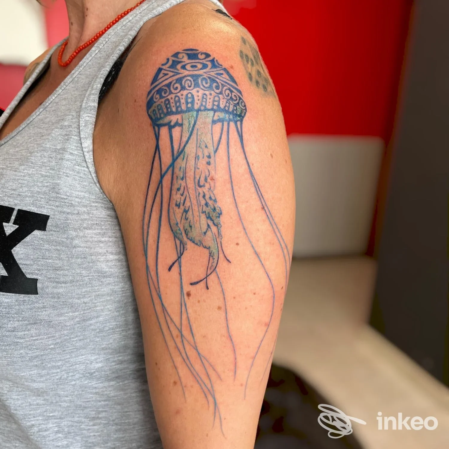 Tattoo sul braccio di una persona, raffigurante una medusa con tentacoli blu, visibile chiaramente, realizzato dallo studio DNA Tattoo a Roseto degli Abruzzi.