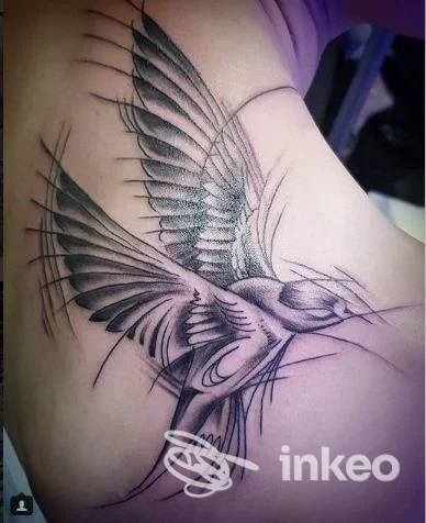 Tattoo realistico di un uccello in volo lungo la scapola, realizzato da Ju Tattoo a L'Aquila.