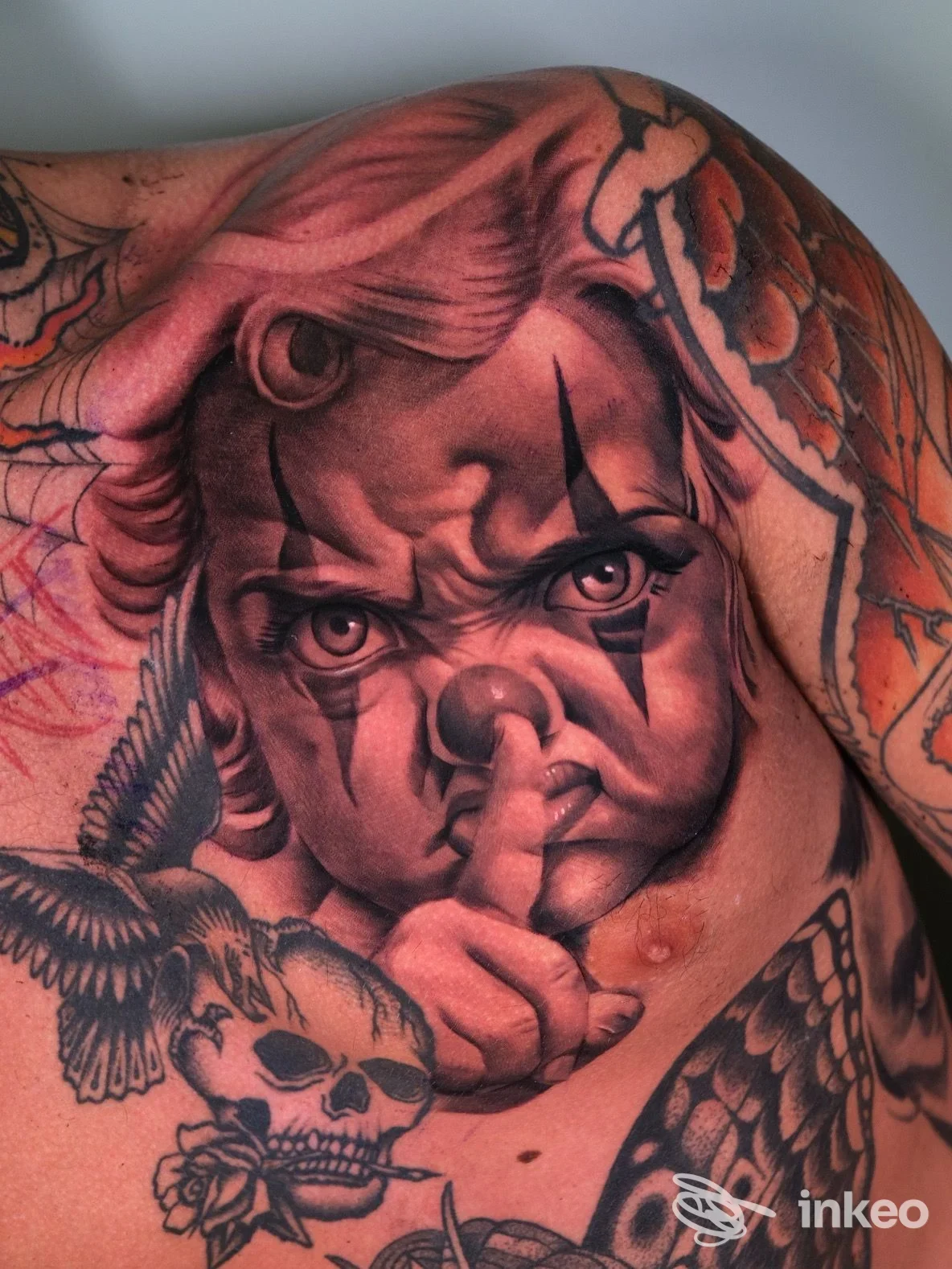 Tattoo realistico su torace raffigurante un volto infantile con mani e sfumato, realizzato dal Harmonink Tattoo Shop a Chieti.