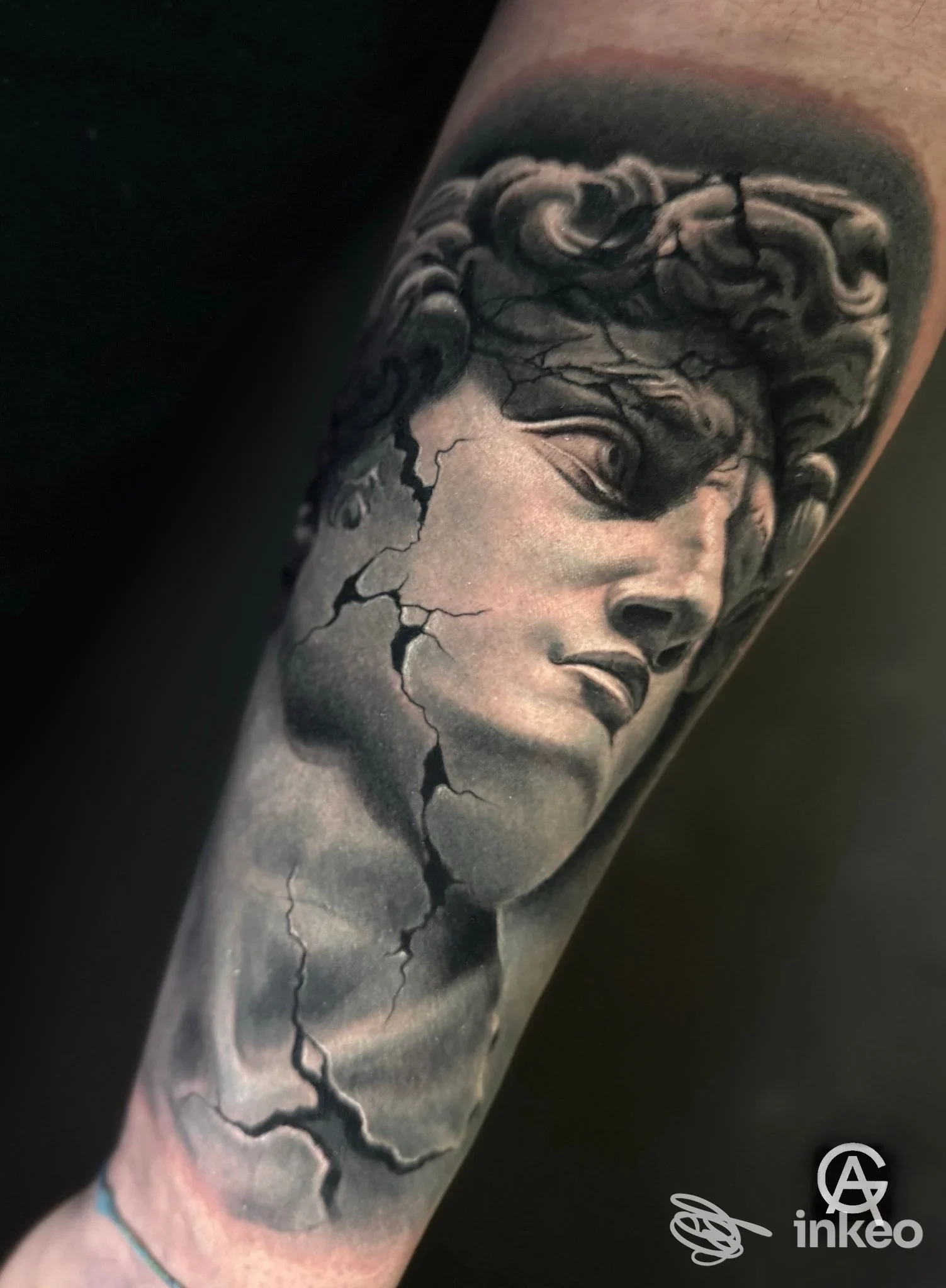 Tattoo in bianco e nero su avambraccio raffigurante una testa di statua classica con crepe, eseguito da Gabriel Andrasi Tattoo, Montesilvano.