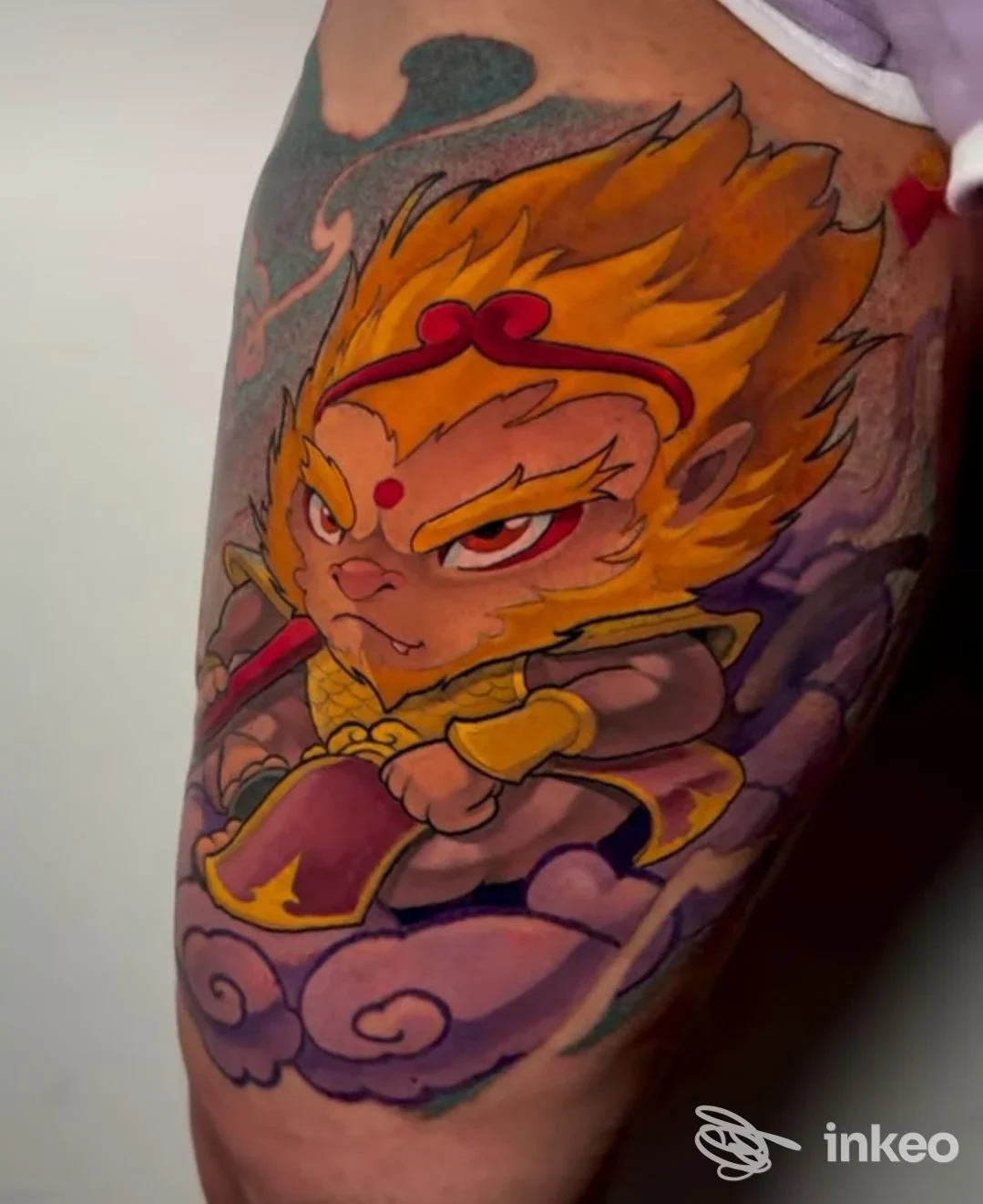 Tattoo a colori su pelle raffigurante un personaggio cartonesco dorato, con nuvole viola, su gamba; studio Inside Tattoo Shop, Alba Adriatica.