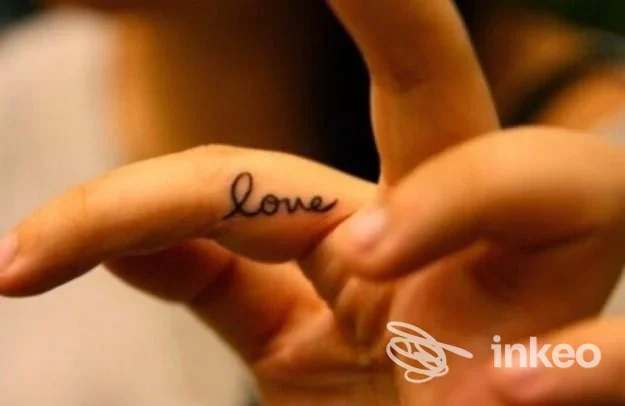 Tatuaggio su dito: scritta Love in stile script visibile sulla pelle, realizzato da Loredana De Luca a Sulmona.