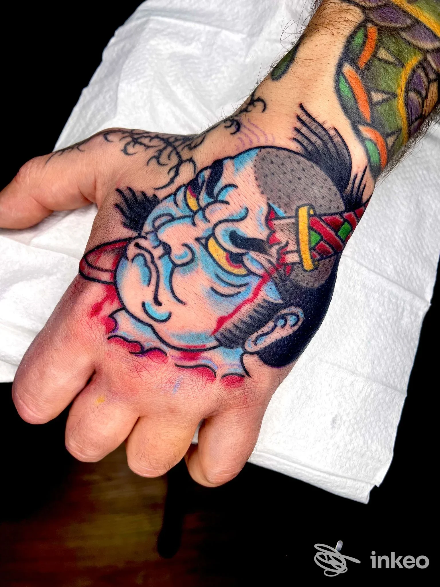 Tattoo sul dorso della mano: disegno colorato e ben definito con stile cartoonesco, senza viso, su pelle reale.