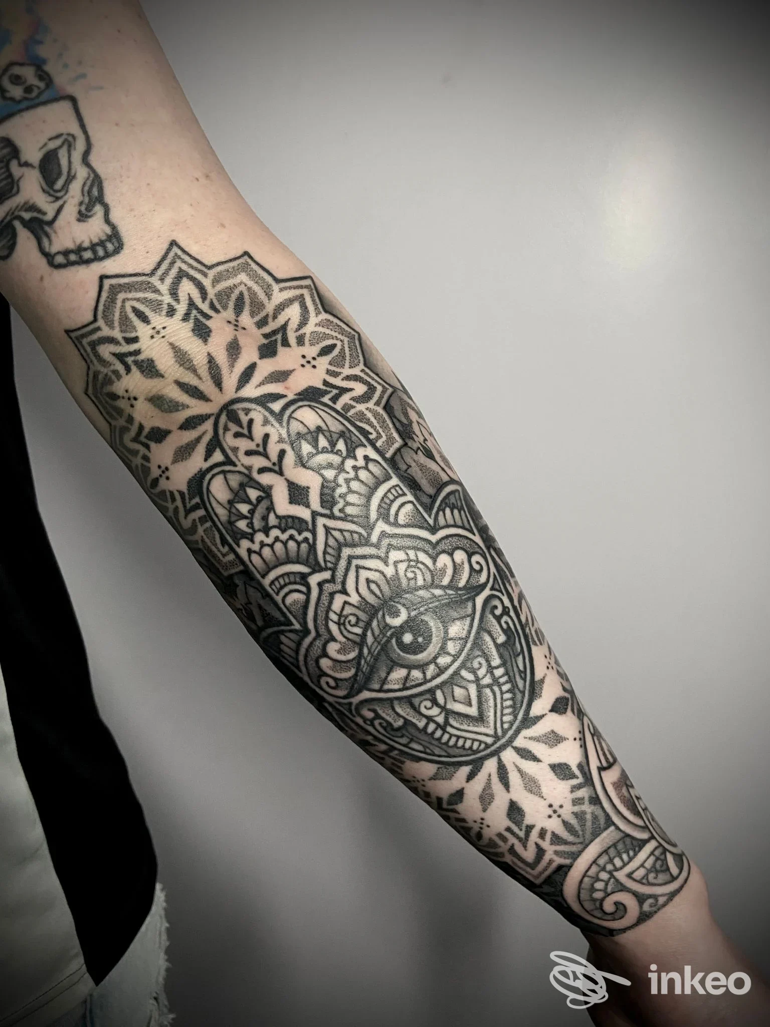 Tattoo reale sull'avambraccio sinistro, stile geometrico mandala con tratteggio nero e grigio, dettaglio chiaro e ben definito.