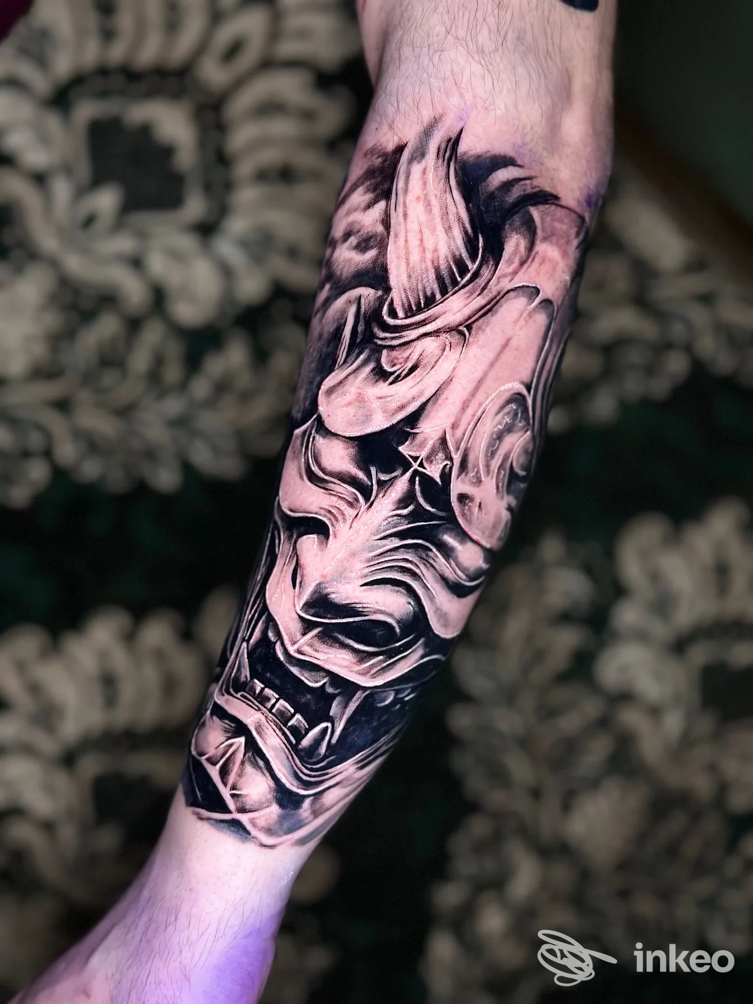 Tatuaggio completo sull’avambraccio raffigurante elementi morbidi e realisti in bianco e nero, con dettagli di luci e ombre evidenti.
