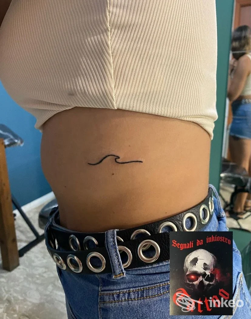 Piccolo tatuaggio lineare a margine della cintura sul fianco sinistro di una persona, con studio Segnali da Inkiostro, Roseto degli Abruzzi.