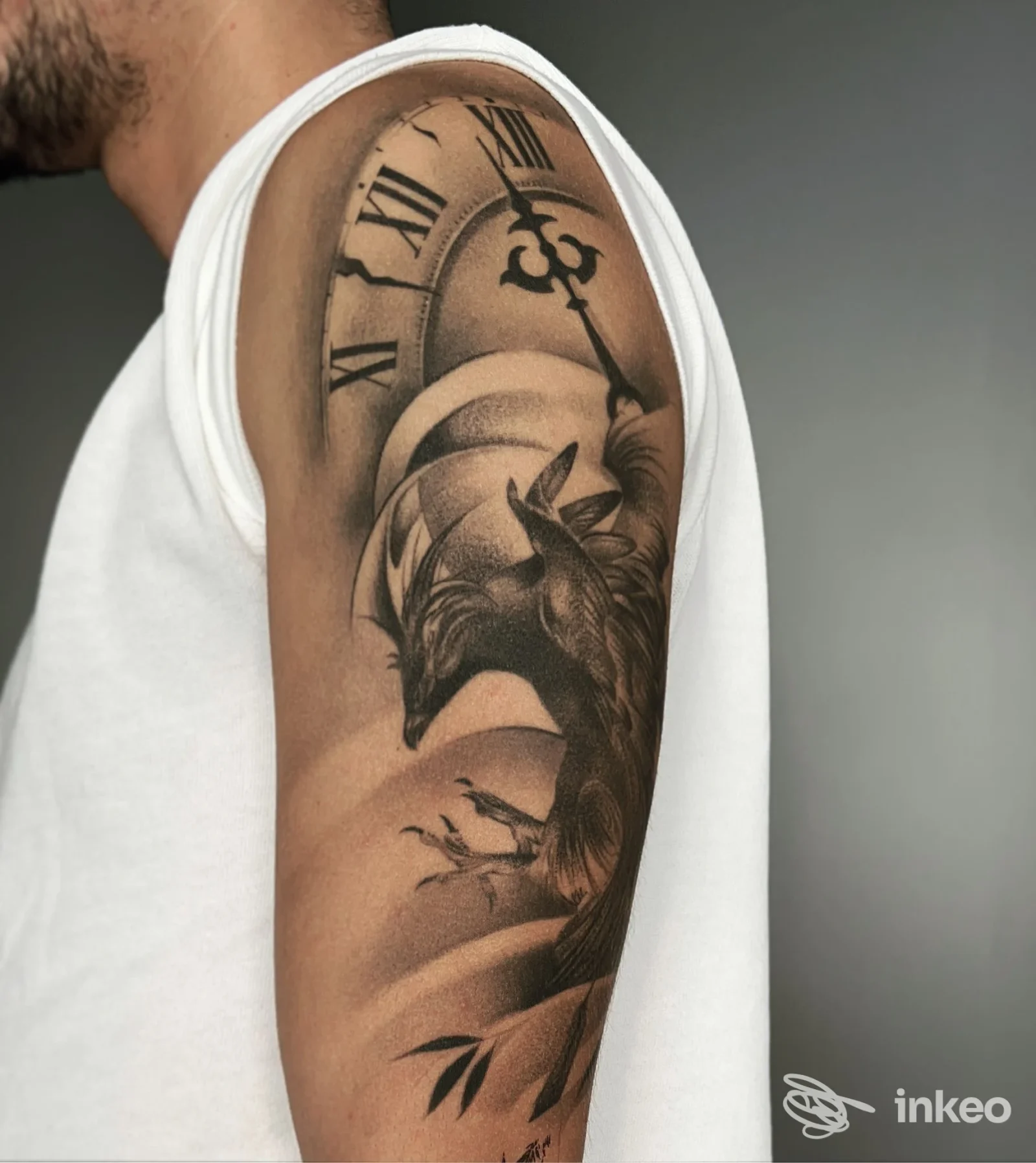Tattoo sul braccio di una persona, con orologio a numeri romani e figura di lupo in bianco e nero; ombreggiature e dettagli realistici sulla pelle.