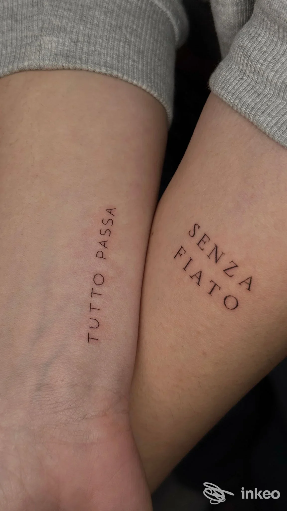 Due avambracci mostrano due tatuaggi verticali sulla pelle: 'TUTTO PASSA' e 'SENZA FIATO' eseguiti da Delos a Montesilvano.
