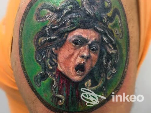 Tatuaggio realistico di Medusa con sfondo verde su braccio, realizzato da Cioci Tattoo Studio a Teramo.