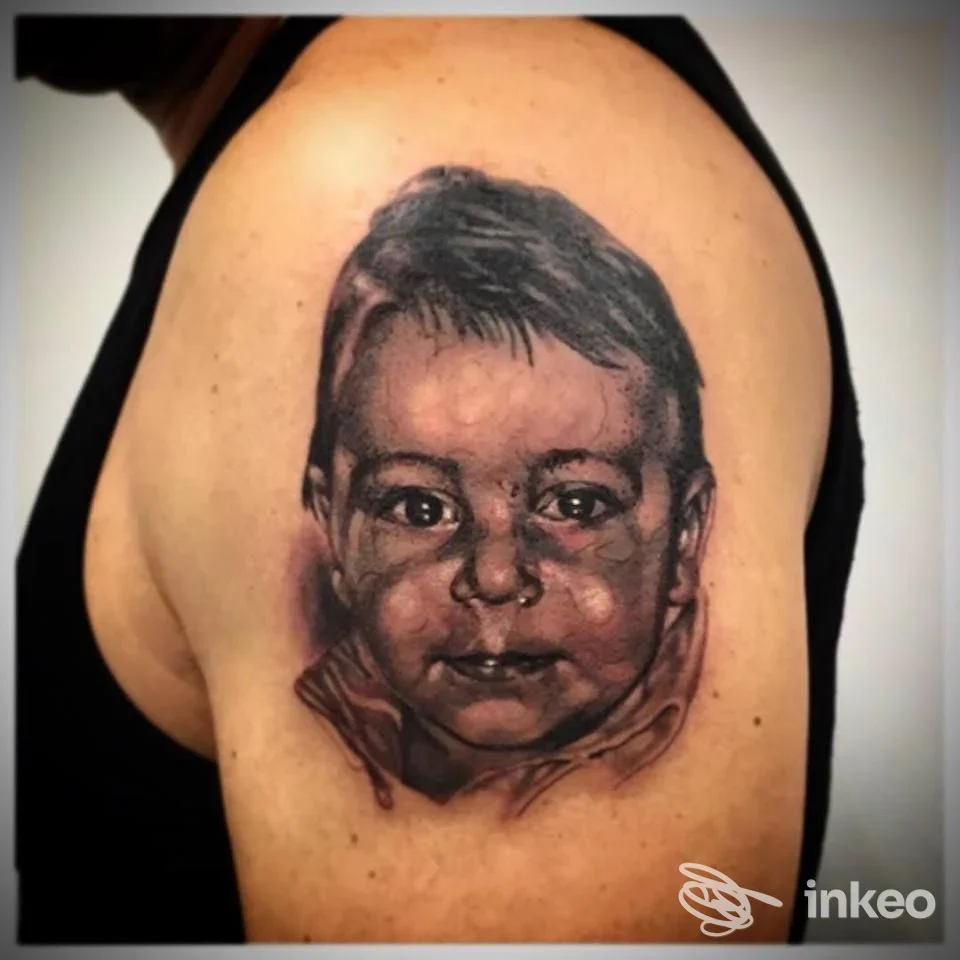 Tattoo realistico su braccio raffigurante il volto di un bambino, realizzato in Cioci Tattoo Studio a Teramo.