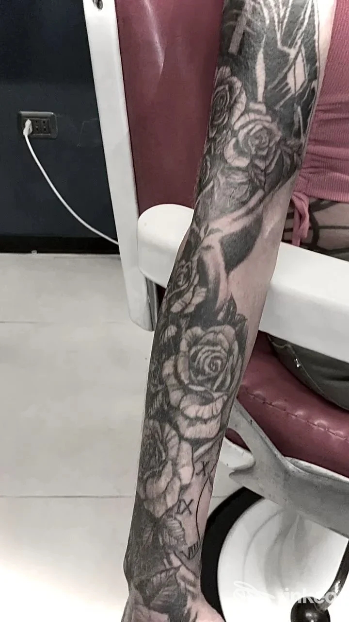 Primo piano di avambraccio con tatuaggio a tema rose realizzato sulla pelle, visibile in ambientazione studio; firma MonelloTattoo, Giulianova.