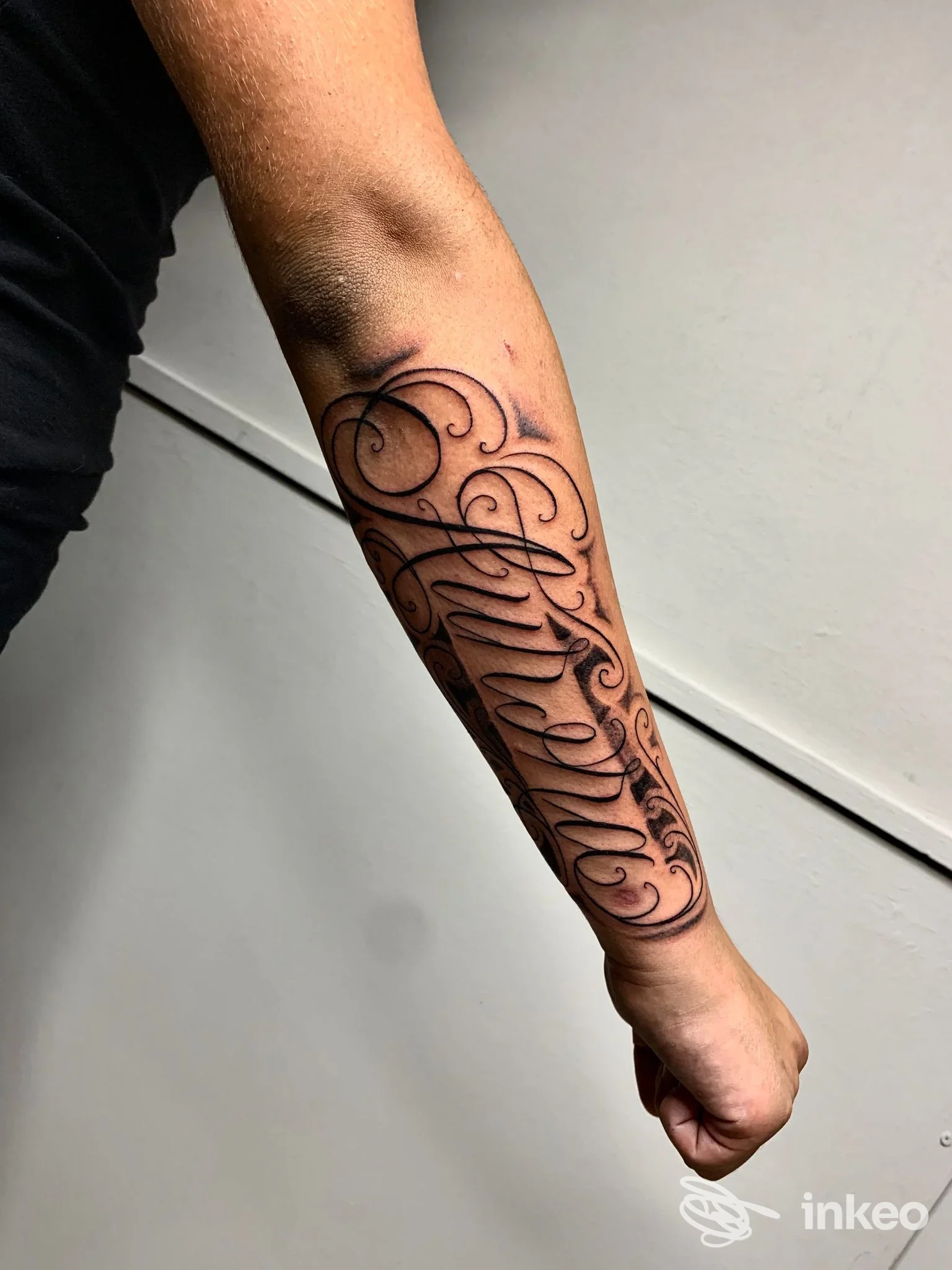 Avambraccio di una persona con un elegante tatuaggio ornato lungo tutta la parte anteriore dell’avambraccio, realizzato da Dave Tattoo Studio, Giulianova.