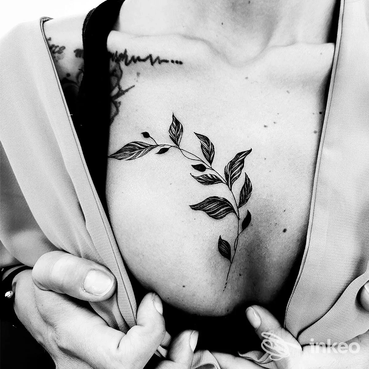 Tattoo visibile su petto, motivo di rami e foglie in bianco e nero, senza interruzioni o elementi di interfaccia sociale; studio Ivre, Silvi.
