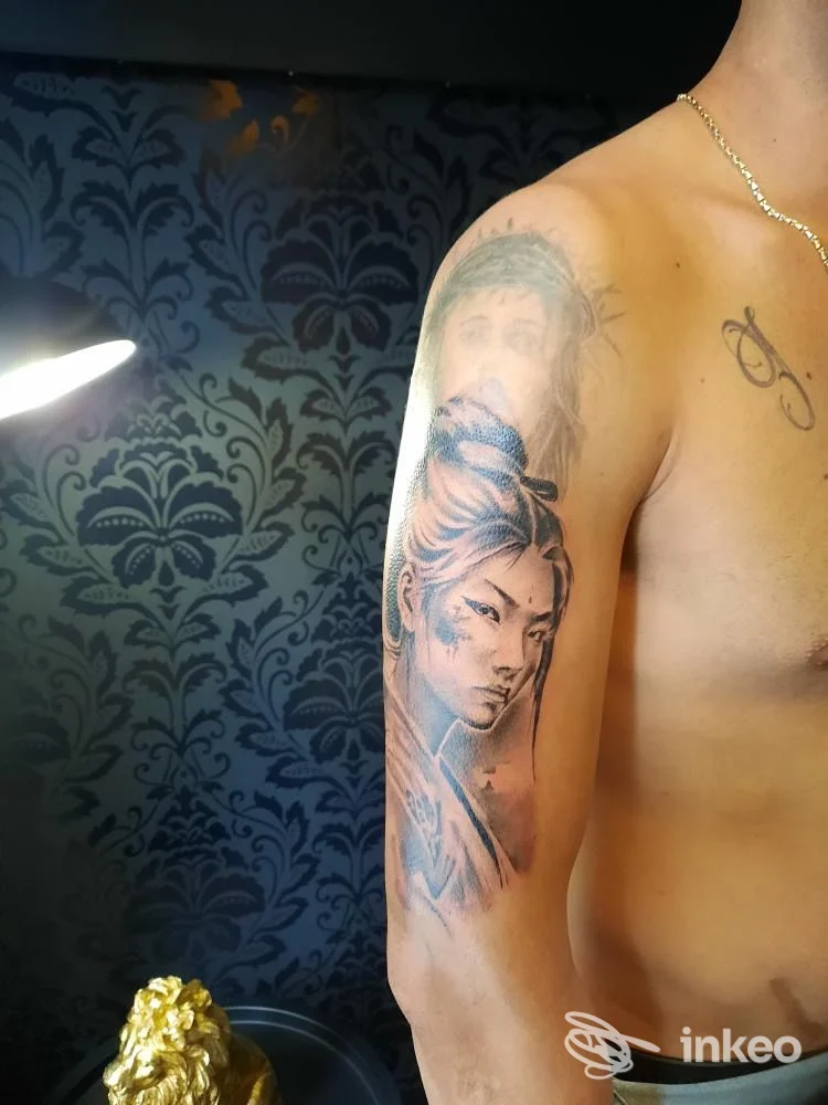 Tattoo realistico sul braccio di un uomo, ritratto parziale visibile, eseguito nello studio Rey Tattoo a Lamezia Terme.