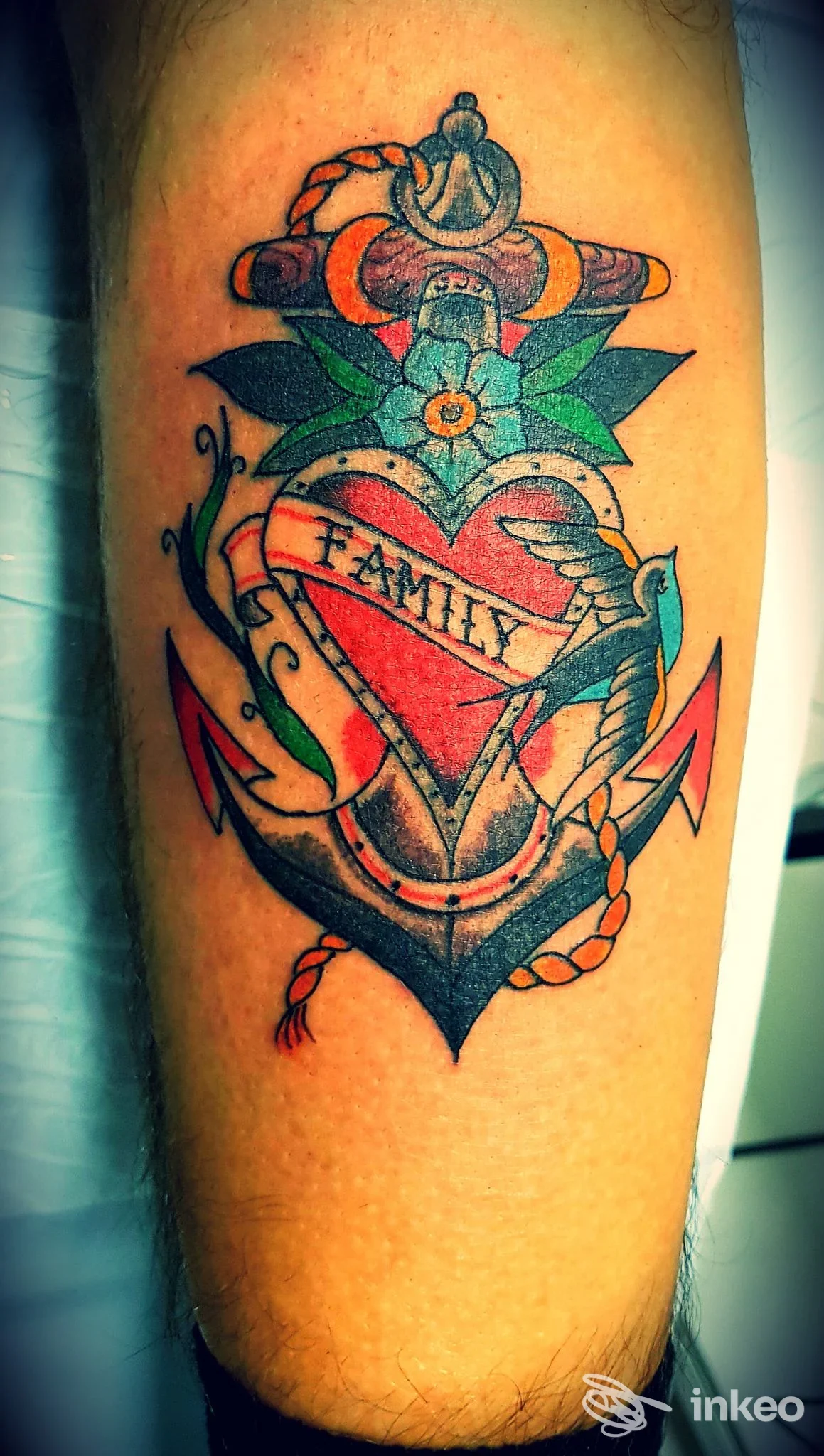 Tatuaggio a colori su pelle raffigurante cuore con banner FAMILY, ancora e fiori, realizzato in Tattoo's Way a Reggio Calabria.