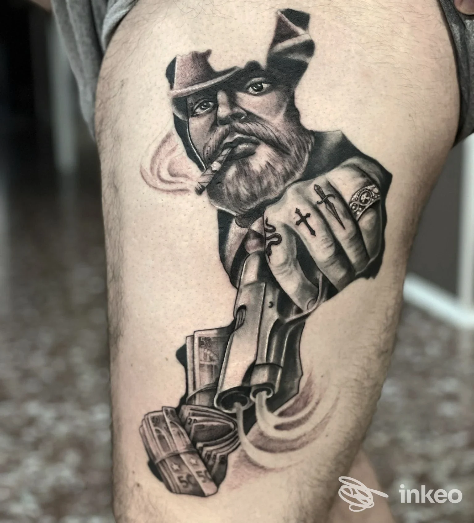 Tattoo realistico su pelle raffigurante una figura con cappello e pistola, in bianco e nero, eseguito allo studio Neocastrum Tattoo di Lamezia Terme.