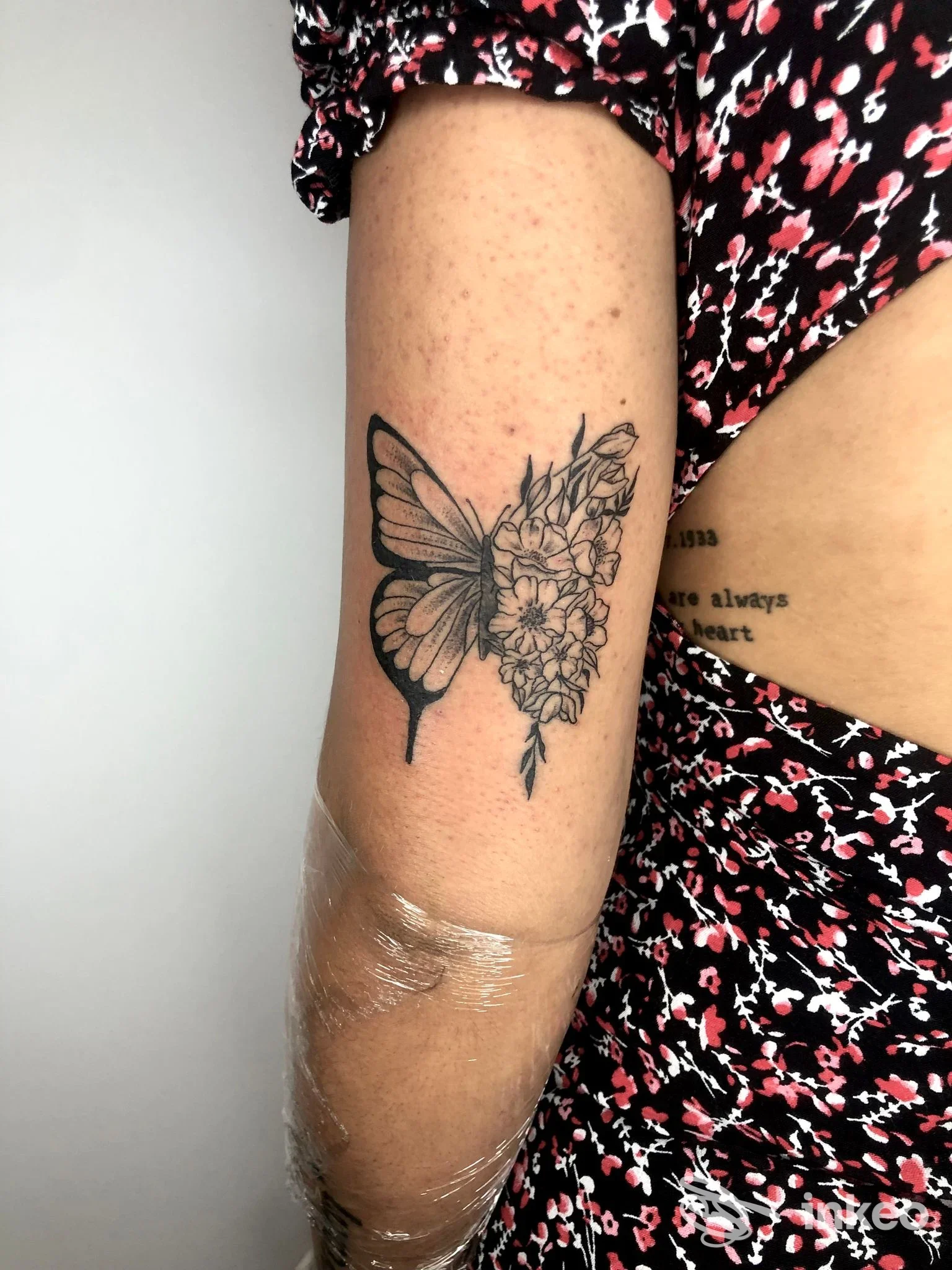 Tattoo su avambraccio: una farfalla stilizzata a sinistra con bouquet di fiori, realizzata su pelle; l'immagine proviene dallo studio Il Tattooificio, Quattromiglia.