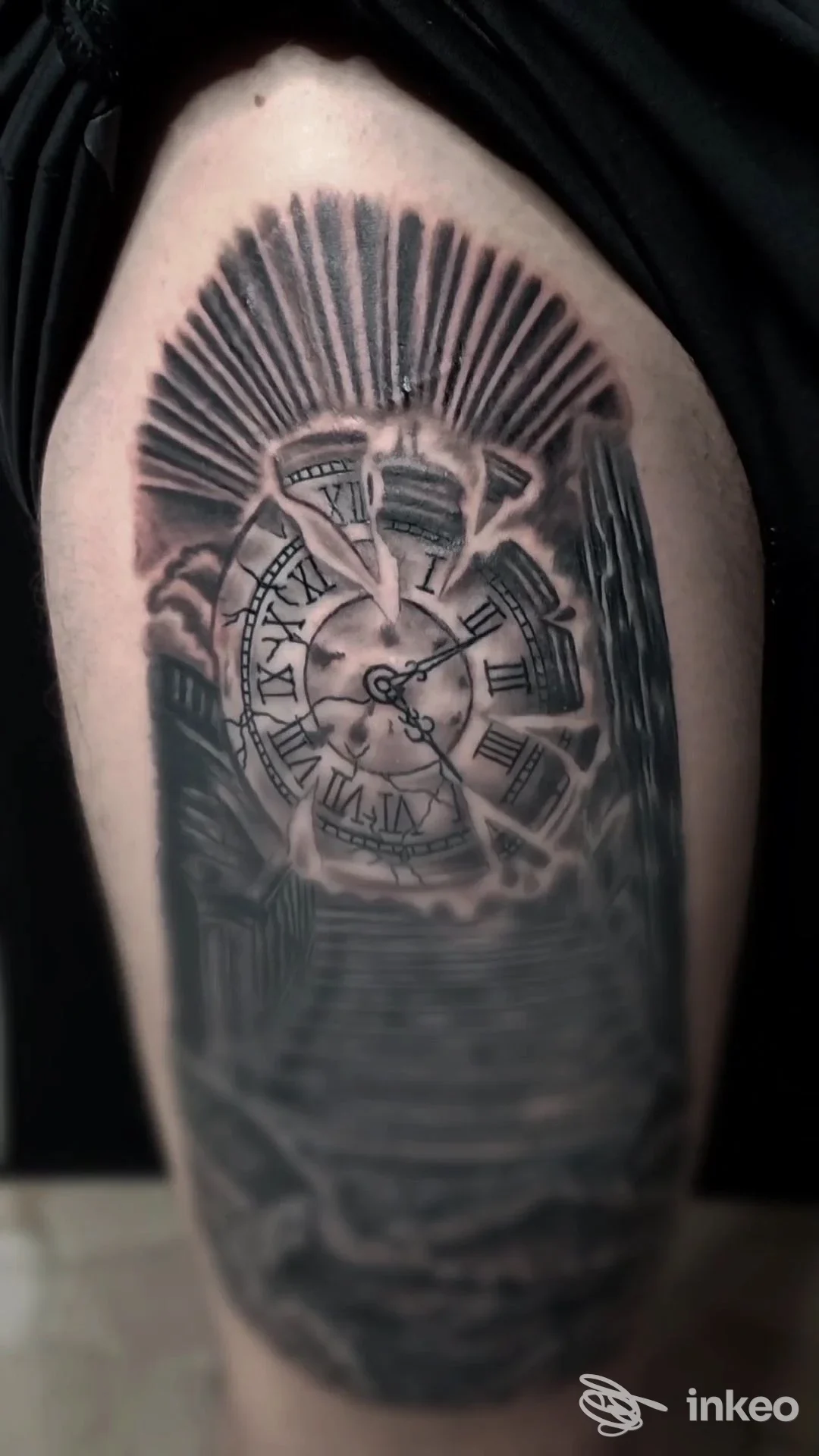 Tattoo su braccio raffigurante un orologio con numeri romani e raggi, realizzato in tonalità nere e grigie, su pelle naturale. Studio Tattooland 8.
