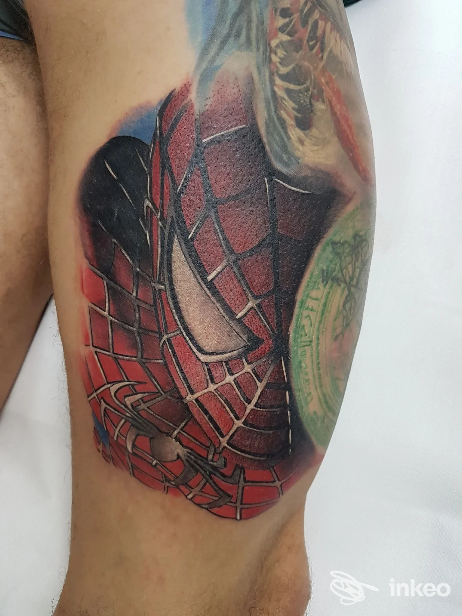 Tattoo realistico sul braccio raffigurante rete e motivo Spider-Man, colori rosso e nero, eseguito nello studio Taratatu' a Palmi.