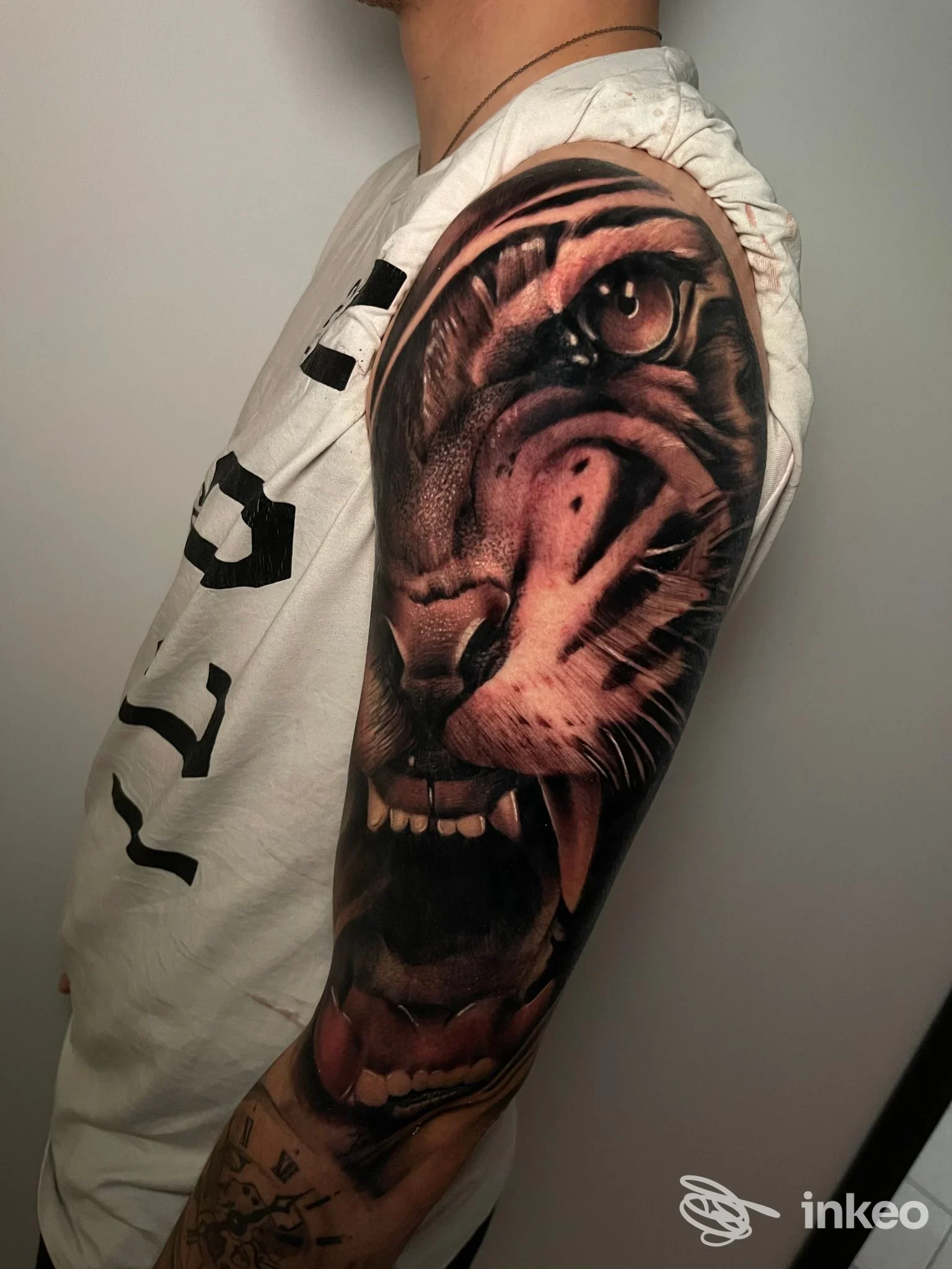 Dettagliato tatuaggio realistico di una tigre coprente il braccio di una persona, tonalità scure e contrasti marcati.