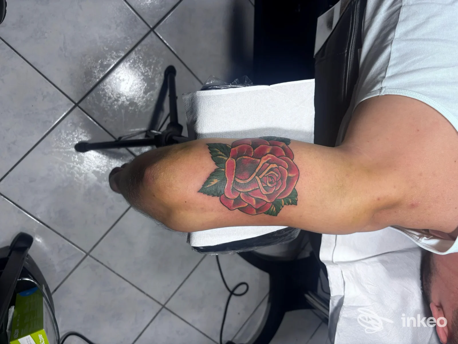 Tatuaggio realistico a colori di una rosa sul muscolo dell’avambraccio, eseguito su pelle reale, visibile con tonalità rosse e verdi, studio InkFinity Tattoo, Amantea.