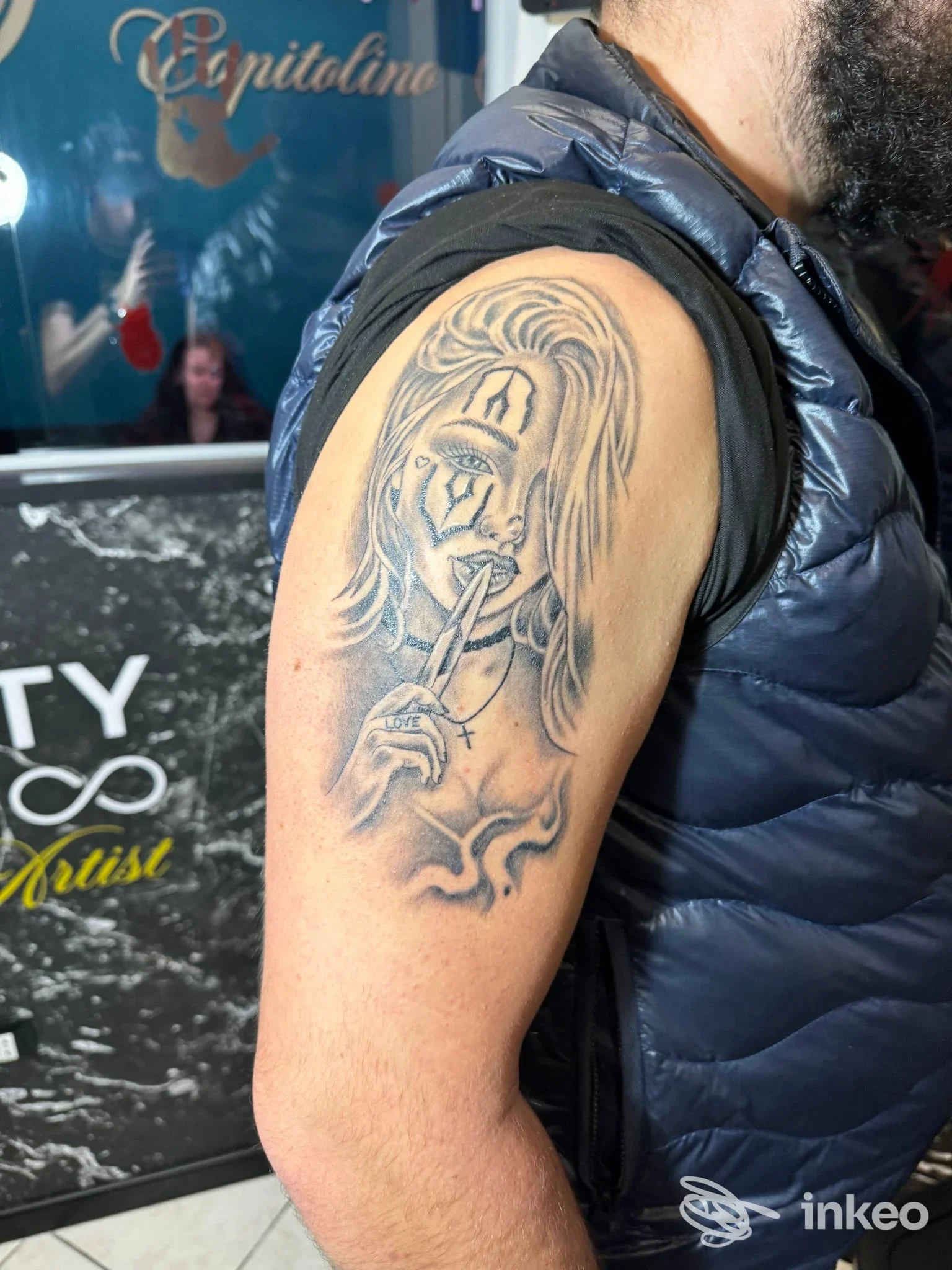 Tatuaggio sul braccio, realizzato da InkFinity Tattoo ad Amantea, raffigura una figura femminile con la mano alzata e elementi decorativi.