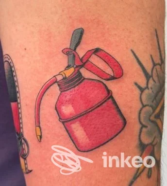 Tattoo raffigurante un estintore rosso visibile sul braccio, realizzato sulla pelle, stile cartoonesco.