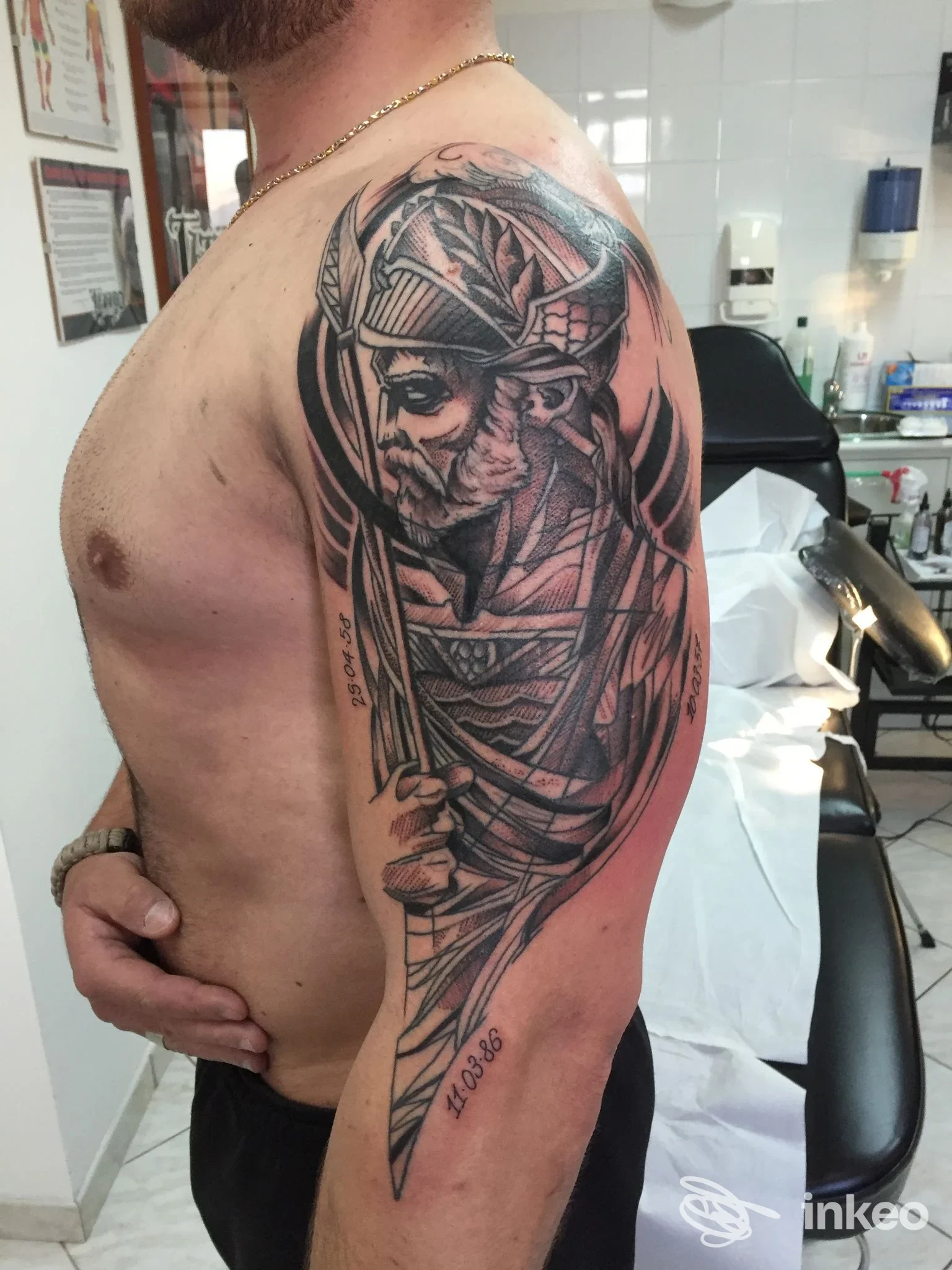 Tatuaggio in stile guerriero su braccio sinistro di un uomo, eseguito presso Gigiz Tattoo Art Studio a San Nicola Arcella, visibile in alto braccio e spalla con dettagli in nero e grigio.