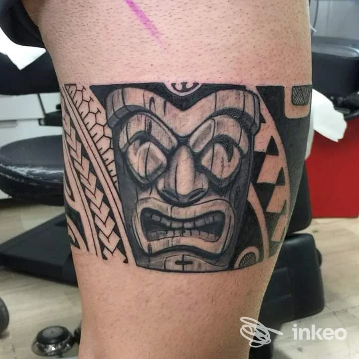 Tatuaggio in bianco e nero su pelle, raffigurante una maschera stilizzata; realizzato dallo Studio Roberto Rogolino a Reggio di Calabria.