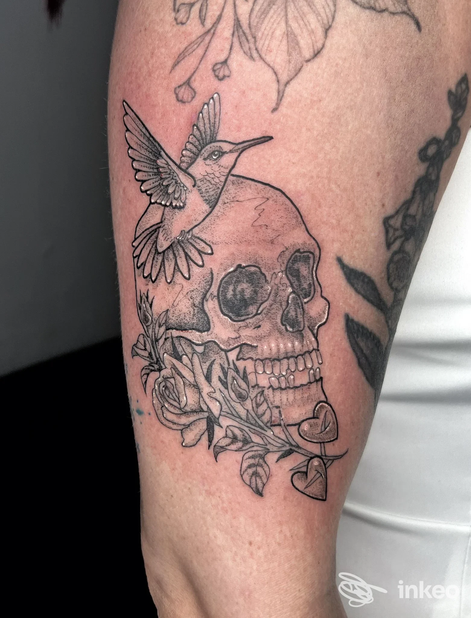 Tattoo su avambraccio destro raffigurante teschio con colibrì in volo e rami con foglie e fiori, realizzato da Black Dalia Tattoos a Reggio di Calabria