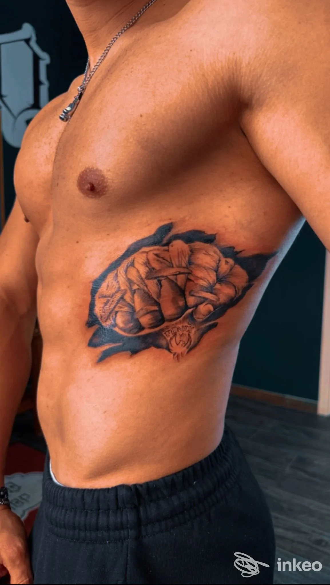 Tatuaggio reale di un grande fiore su torace di uomo, realizzato da El Barrio Tattoo Shop a Vibo Valentia, visibile lateralmente al torace senza volto riconoscibile.