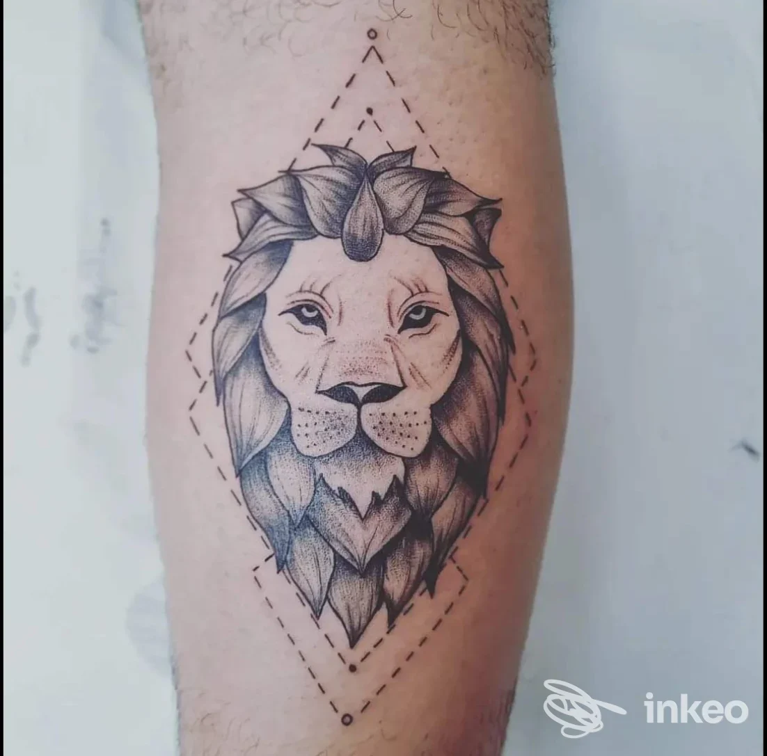 Tatuaggio realistico di leone su avambraccio, con linee nere e shading dettagliato, incorniciato da un motivo geometrico a linha.