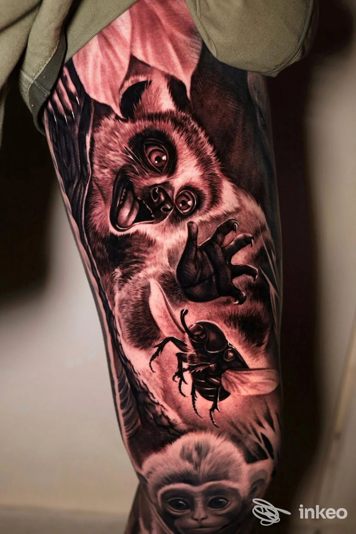 Tattoo realistico su gamba raffigurante panda e insetti, tonalità scure e ombreggiature sottili, realizzato su pelle umana.