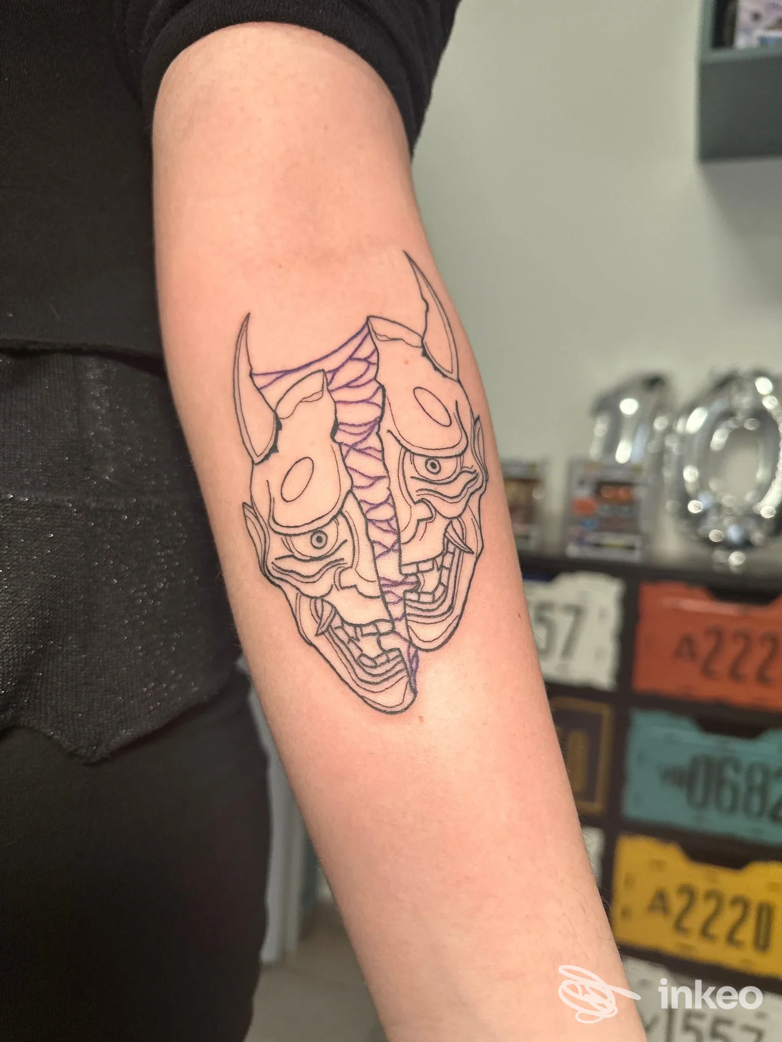 Tattoo a linea nera su avambraccio con motivo demoniaco, contorno definito, pelle chiara. gesto visibile senza elementi di interfaccia o testo estraneo; studio Puciupina Tattoo, Corigliano-Rossano.