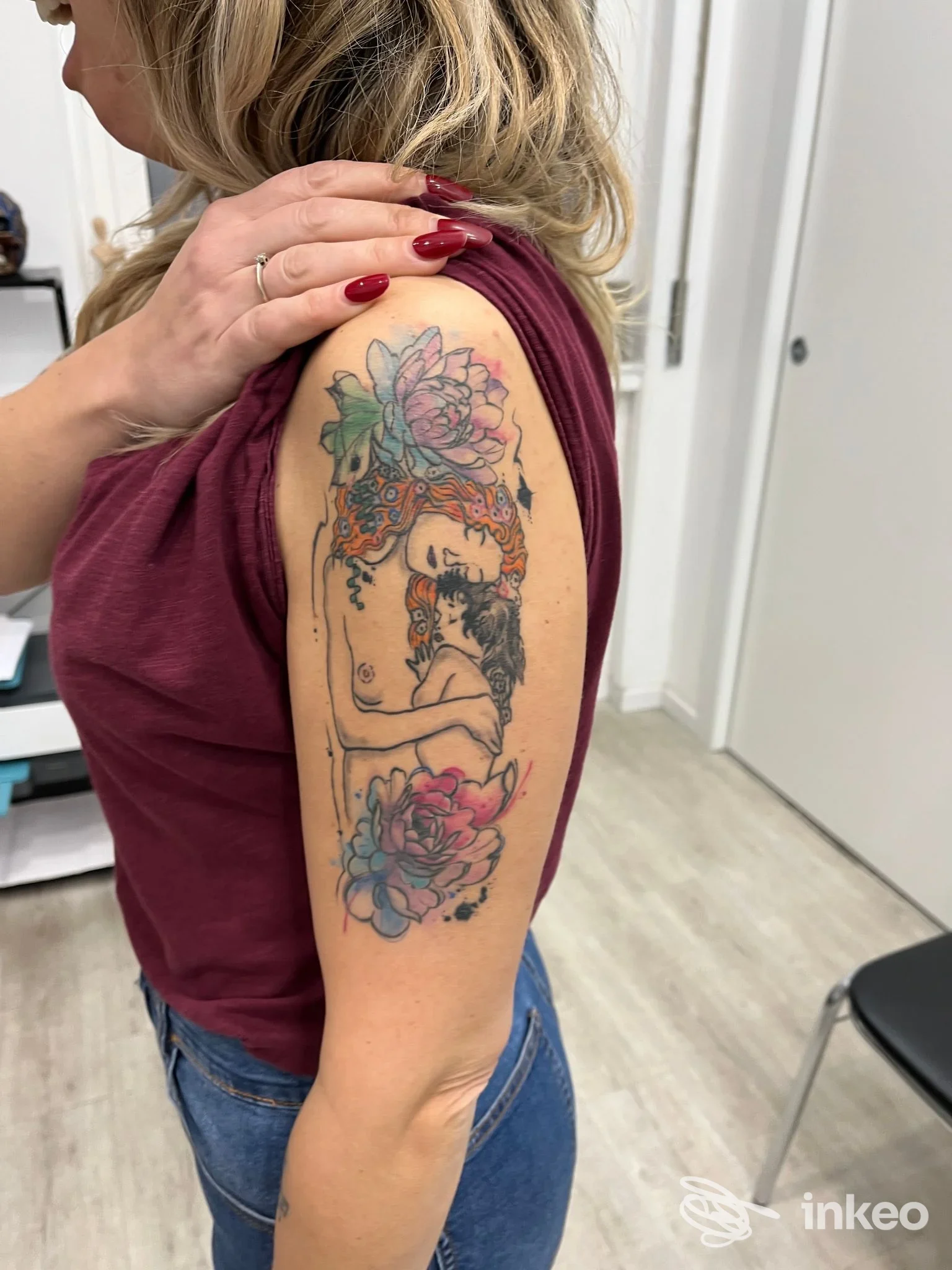 Tattoo visibile sul braccio di una donna: braccio sinistro con disegno a fiori e figura femminile, colori vividi, nessun testo o elemento promozionale.